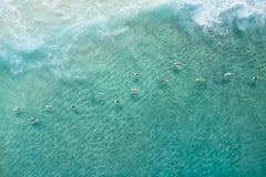 I surfisti si mettono in fila per una serie di onde sul mare blu in questa foto a colori