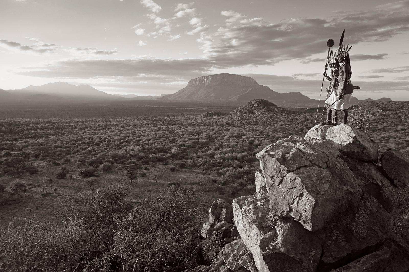 Drew Doggett Black and White Photograph – Zwei Samburu-Krieger stehen auf einem Überblick und betrachten ihr Land