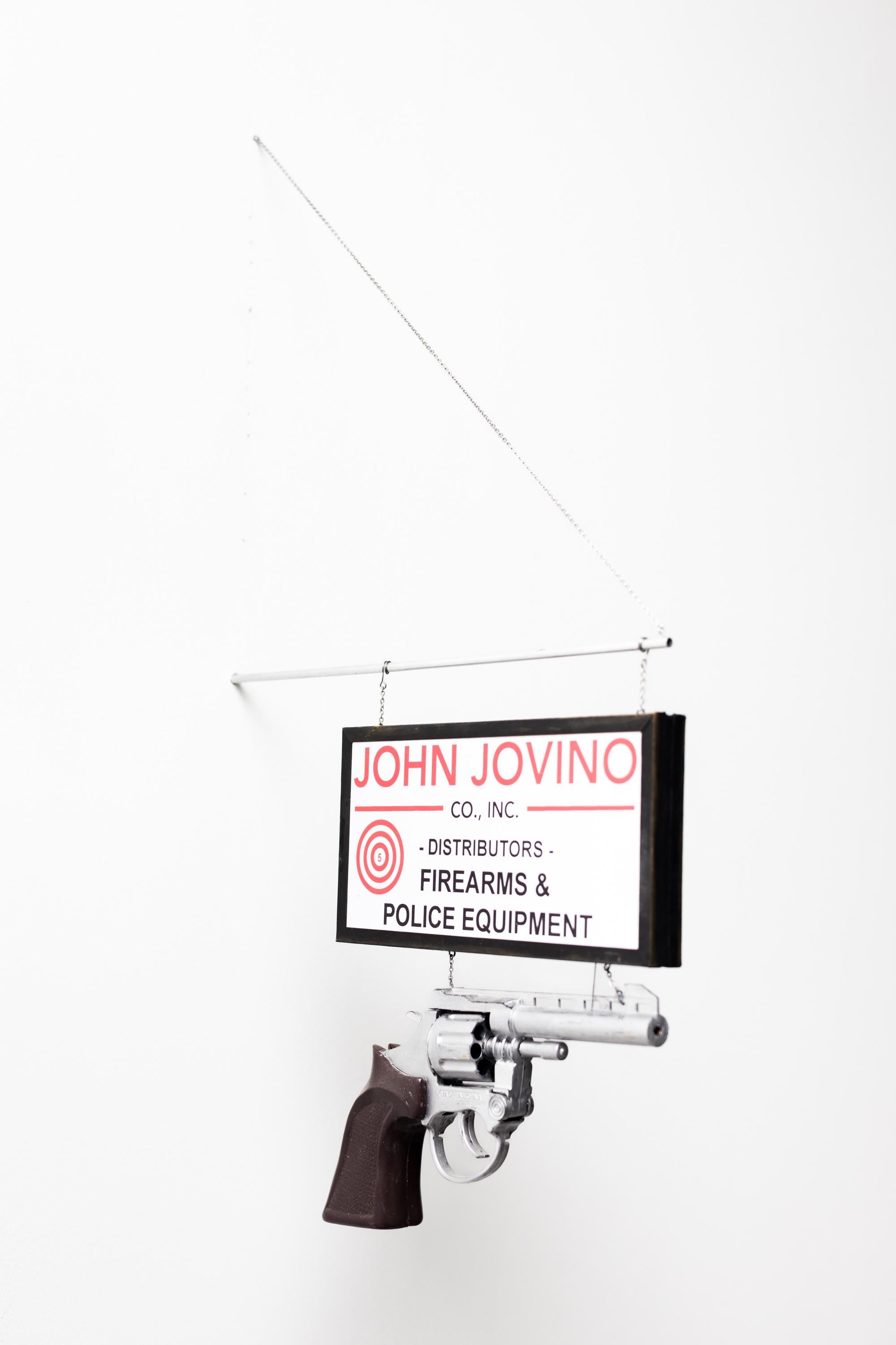 This piece titled "John Jovino’s" is original artwork made from paper, inkjet print, enamel, wire, chain, aluminum tube, pastel, toy gun by Drew Leshko. This piece measures 15”h x 1”w x 11”d.

Drew Leshko is a Philadelphia, Pennsylvania-based