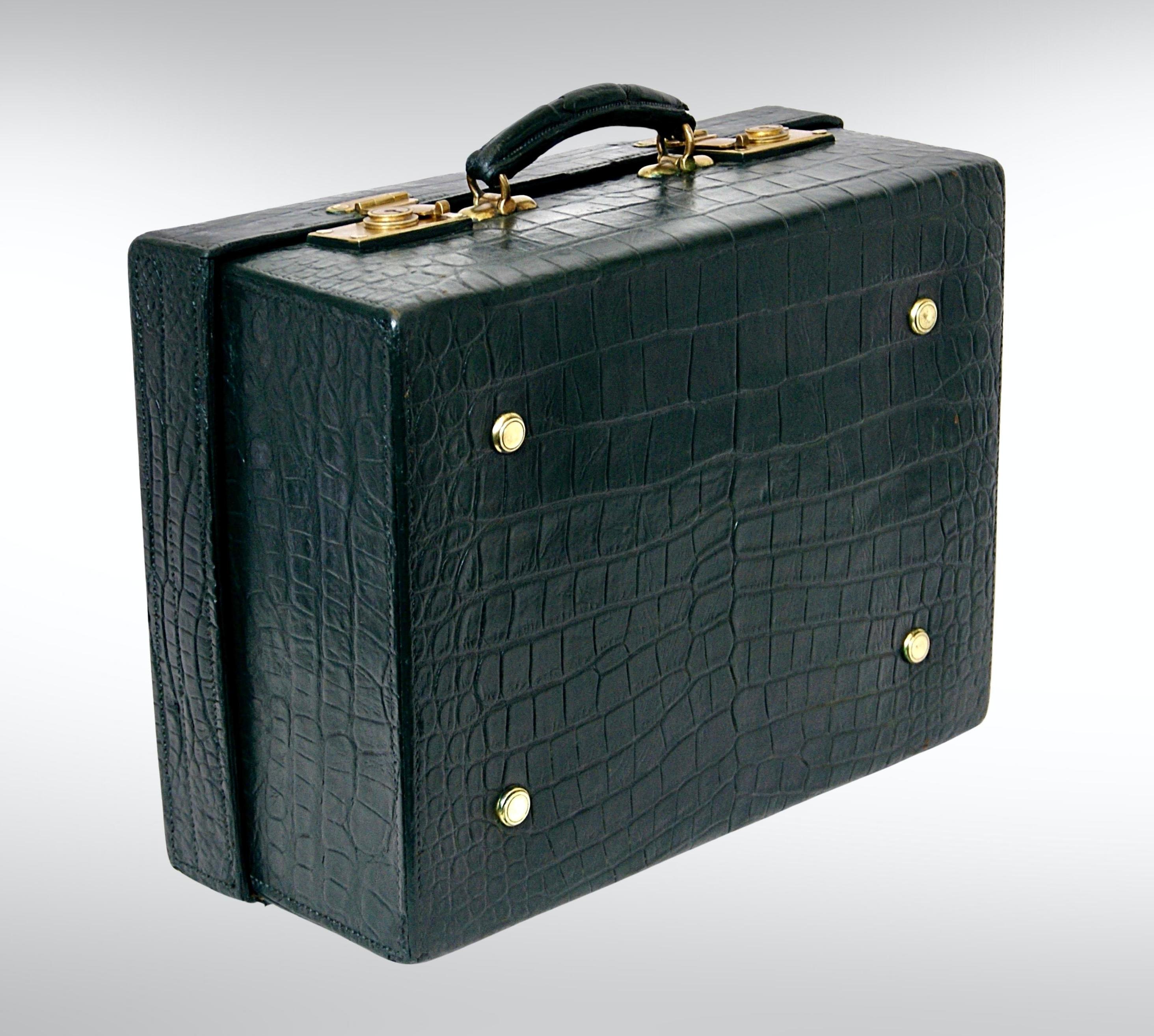 A late Victorian fine crocodile skin travel luggage by Drew & Sons London, circa 1890s.
In dark green colour with brassed lock and catches.
Opening up to reveal matching green lined interior in watered silk, with side pockets for various