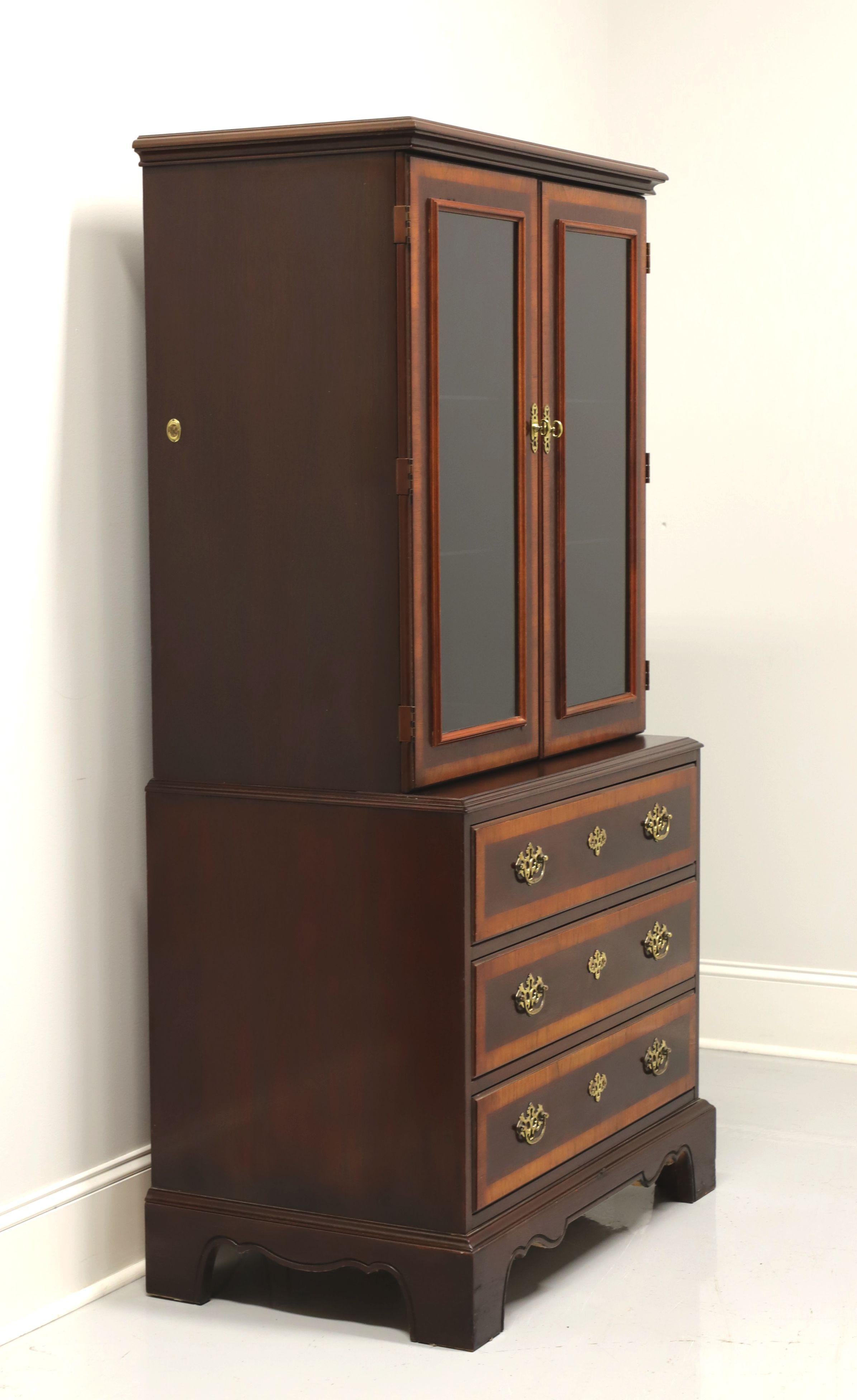A Chippendale style display cabinet by Drexel, from their 18th Century Collection. Banded mahogany with brass hardware. Upper cabinet with dual glass doors, lighted interior and two adjustable glass shelves. Lower cabinet with three drawers of