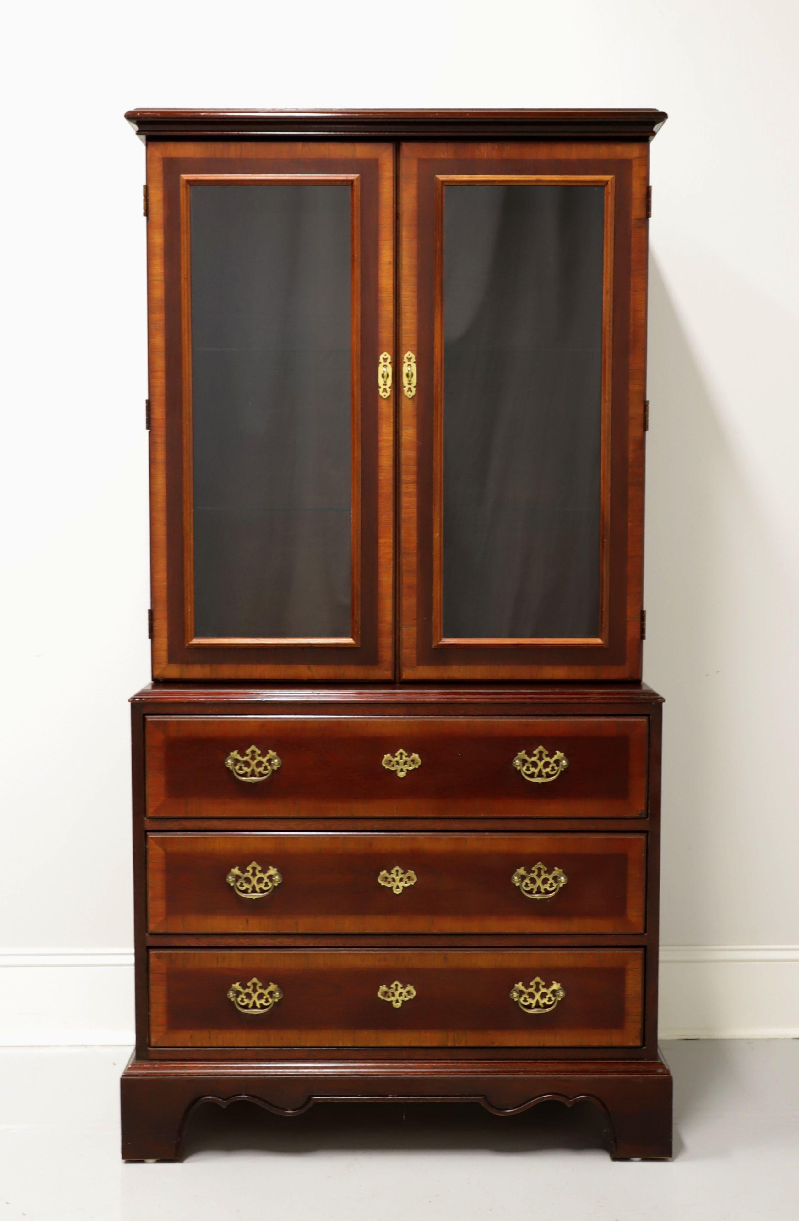 A Chippendale style display cabinet by Drexel, from their 18th Century Collection. Banded mahogany with brass hardware. Upper cabinet with dual glass doors, lighted interior and two adjustable glass shelves. Lower cabinet with three drawers of