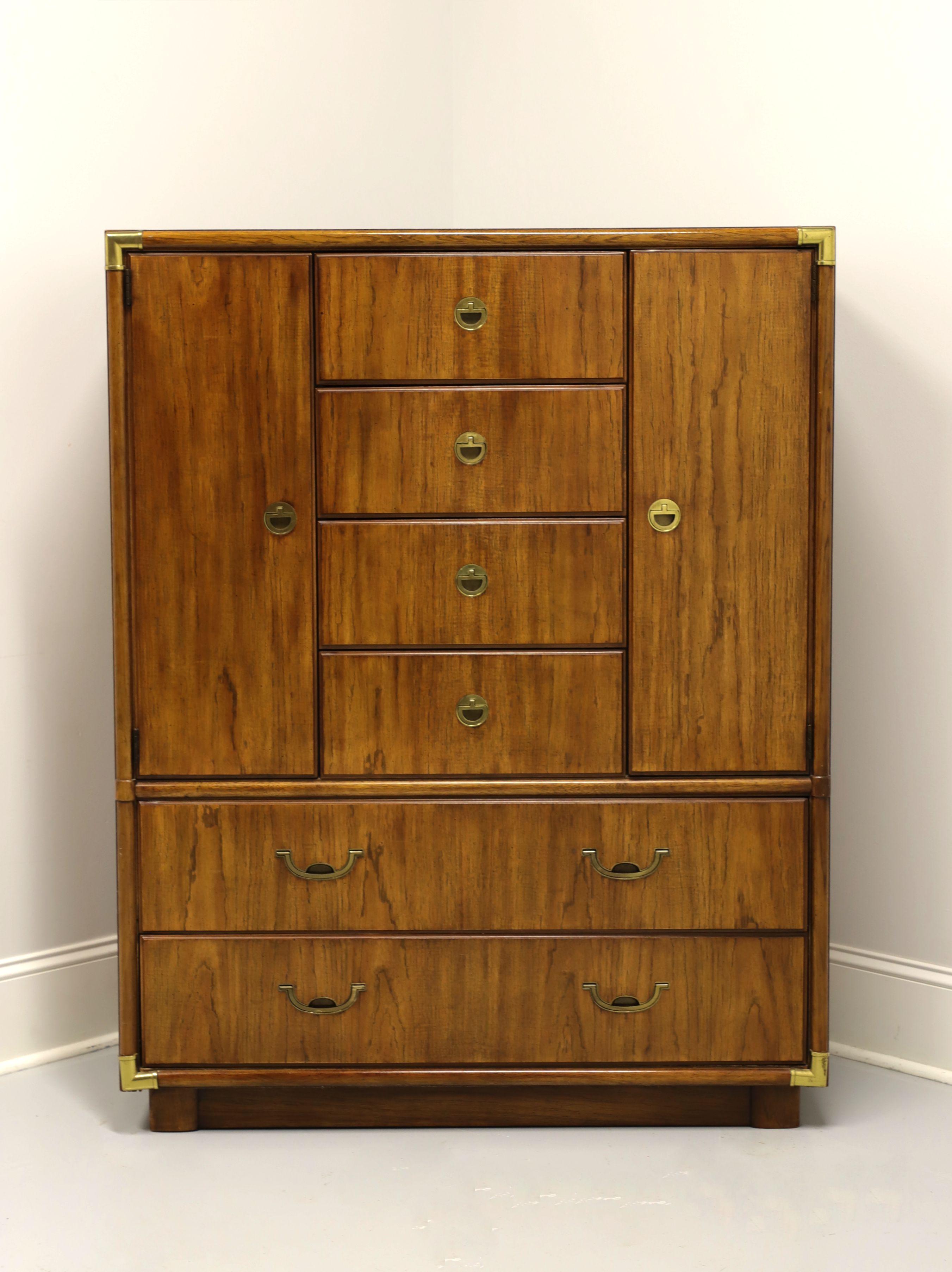 A campaign style gentleman's chest by Drexel, from their Accolade Collection. Pecan with brass accents and hardware. Features four upper center drawers over two lower drawers, all of dovetail construction. Upper center drawers are flanked by dual