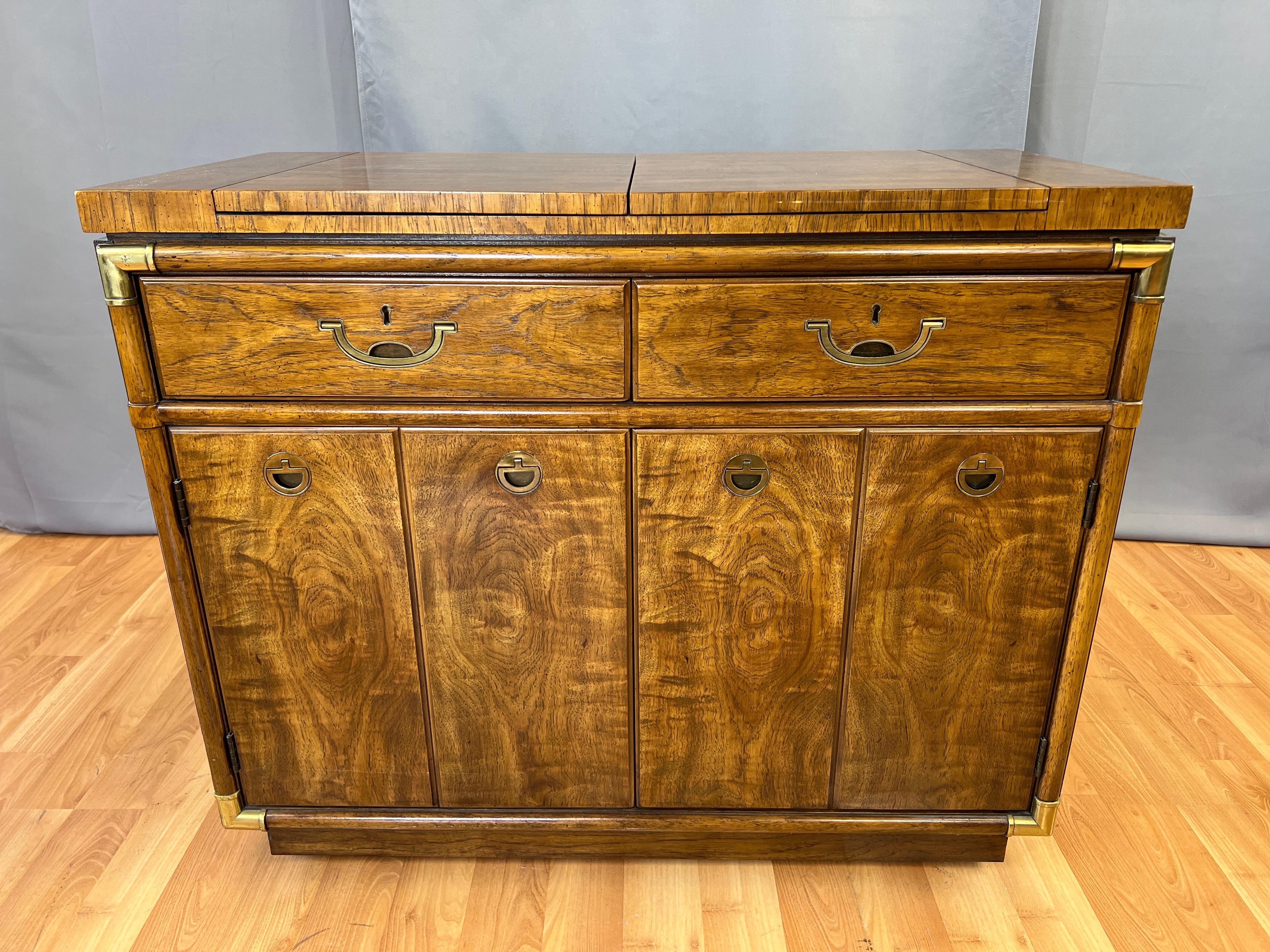 A 1970s campaign-style flip-top rolling dry bar or cabinet from Drexel’s Accolade II collection.

A super handsome piece dressed top-to-bottom and front-to-back in absolutely gorgeous matched flared grain wood (believed to be pecan or something