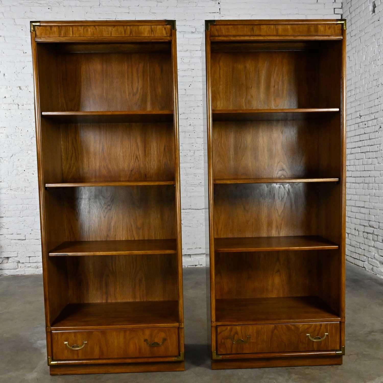 Awesome vintage Drexel Accolade II Collection Campaign style pair of bookcases or display cabinets with 3 shelves, lower drawer with brass plated hardware and corner details. Beautiful condition, keeping in mind that these are vintage and not new so