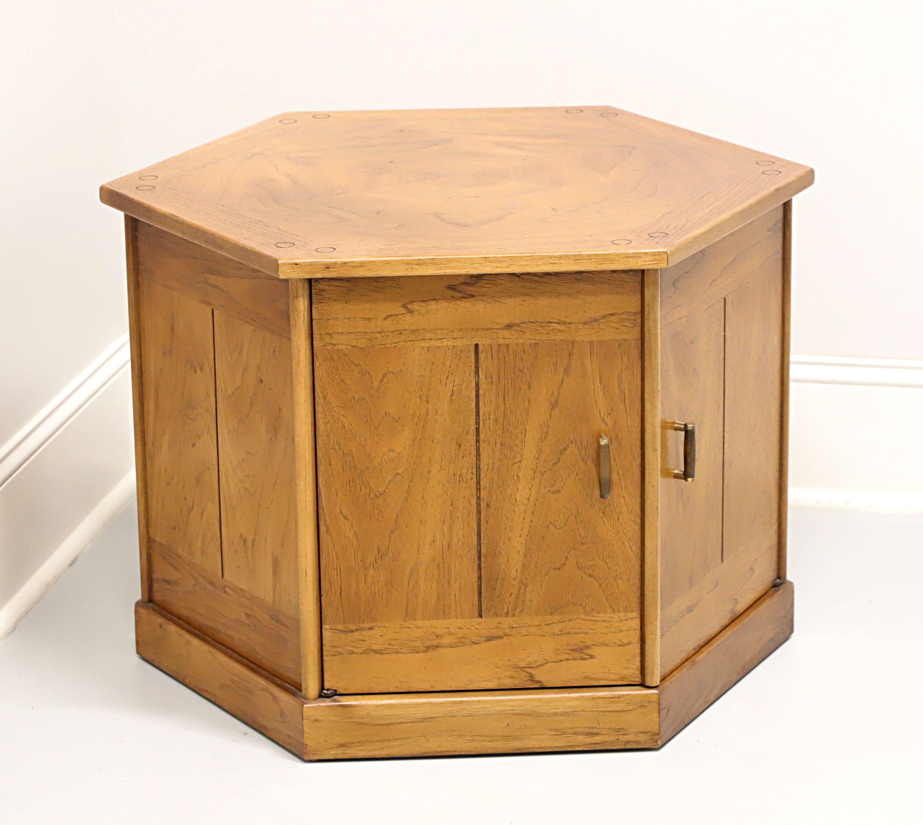 A Mid 20th Century style hexagonal shaped cabinet accent table by Drexel, from their Benchcraft Collection. Pecan with a slightly distressed finish, inlaid & banded top, and brass hardware. Features a two door cabinet revealing a storage area. Made