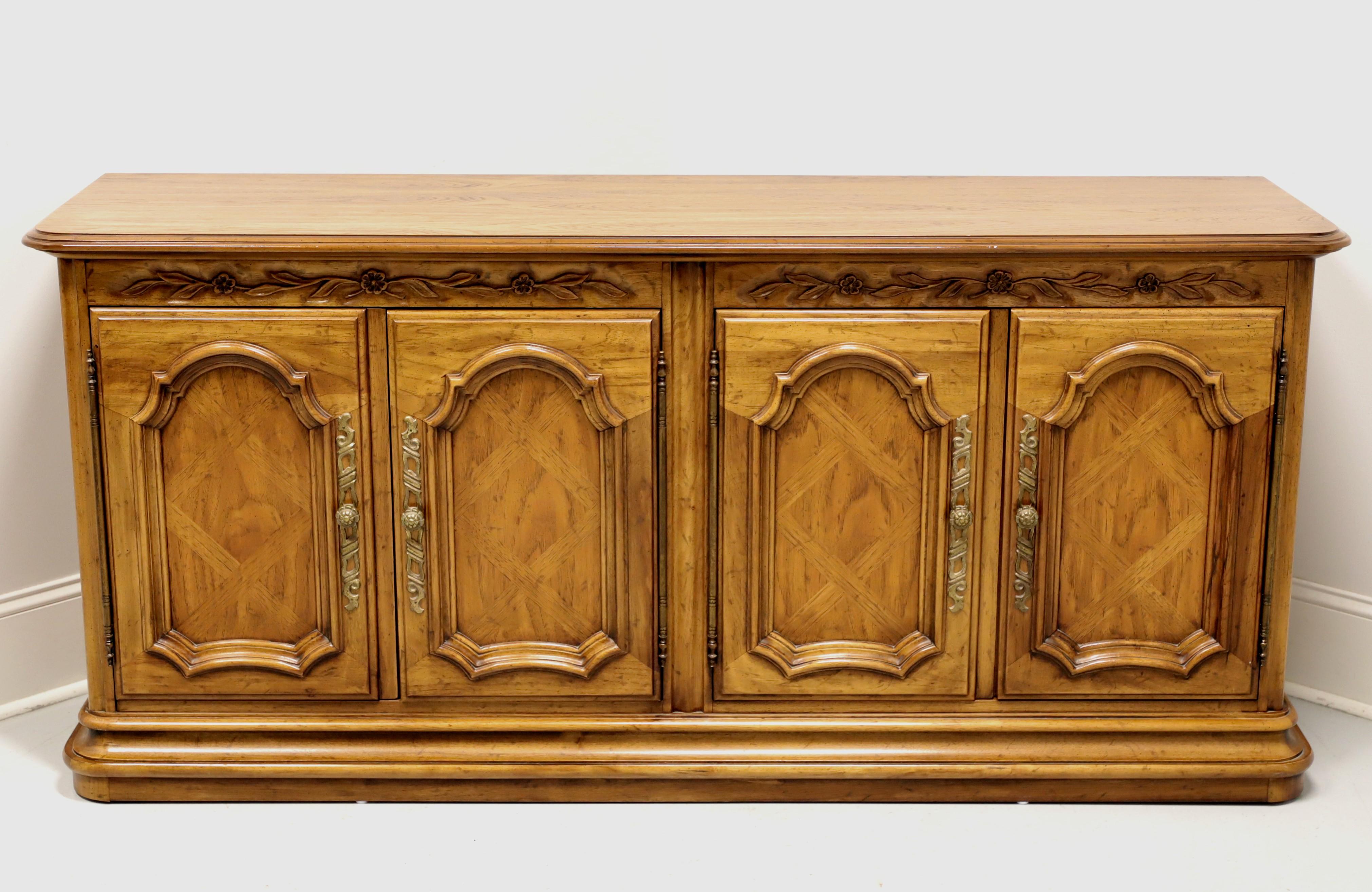 A French Country style credenza by Drexel, from their Cabernet Collection. Solid pecan with parquetry to door fronts and brass hardware. Features four raised panel doors revealing to right side a storage area with one fixed wood shelf and to left