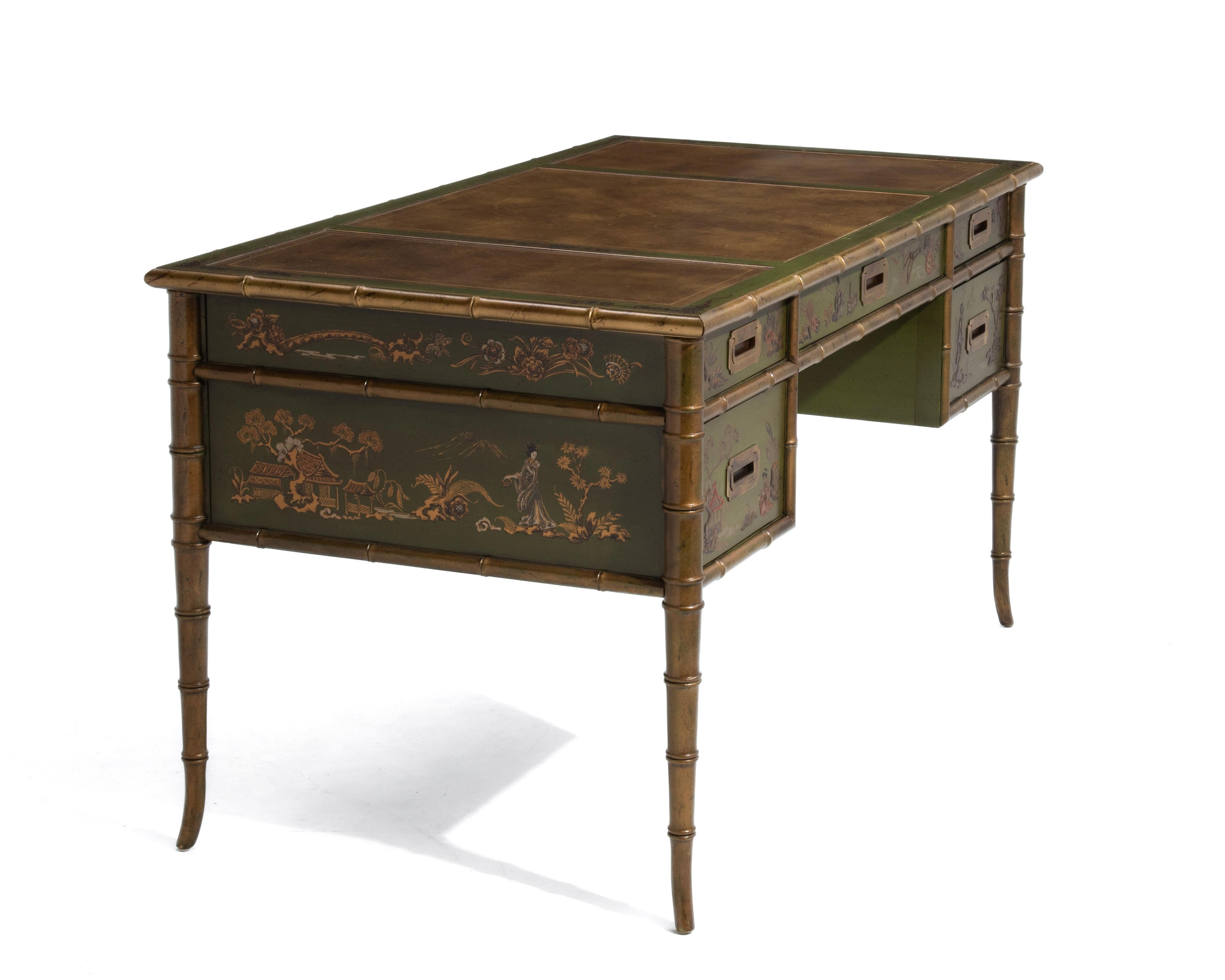 Uno splendido scrittoio Campaigner in stile Chinoiserie di Drexel, anni '60. Completamente marcata, la scrivania presenta dettagli dipinti a mano, figure in bassorilievo, un piano in pelle a tre pannelli, ferramenta in ottone e graziose gambe in
