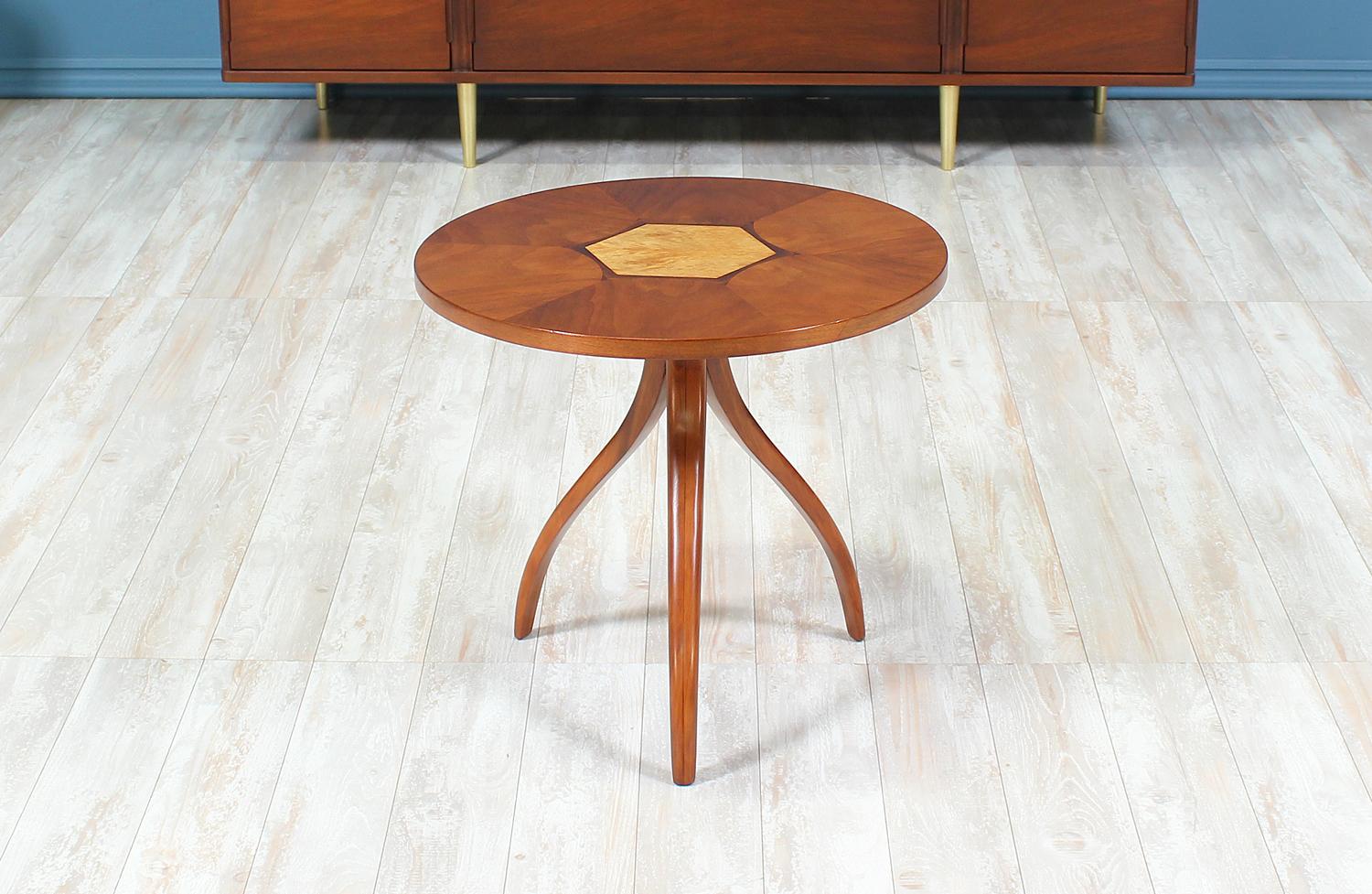 Unique side table manufactured by Drexel for their “Composite” series in the United States circa 1960’s. Beautifully crafted in walnut wood, this side table features sculptural tripod legs that support the round table top which displays a variety of