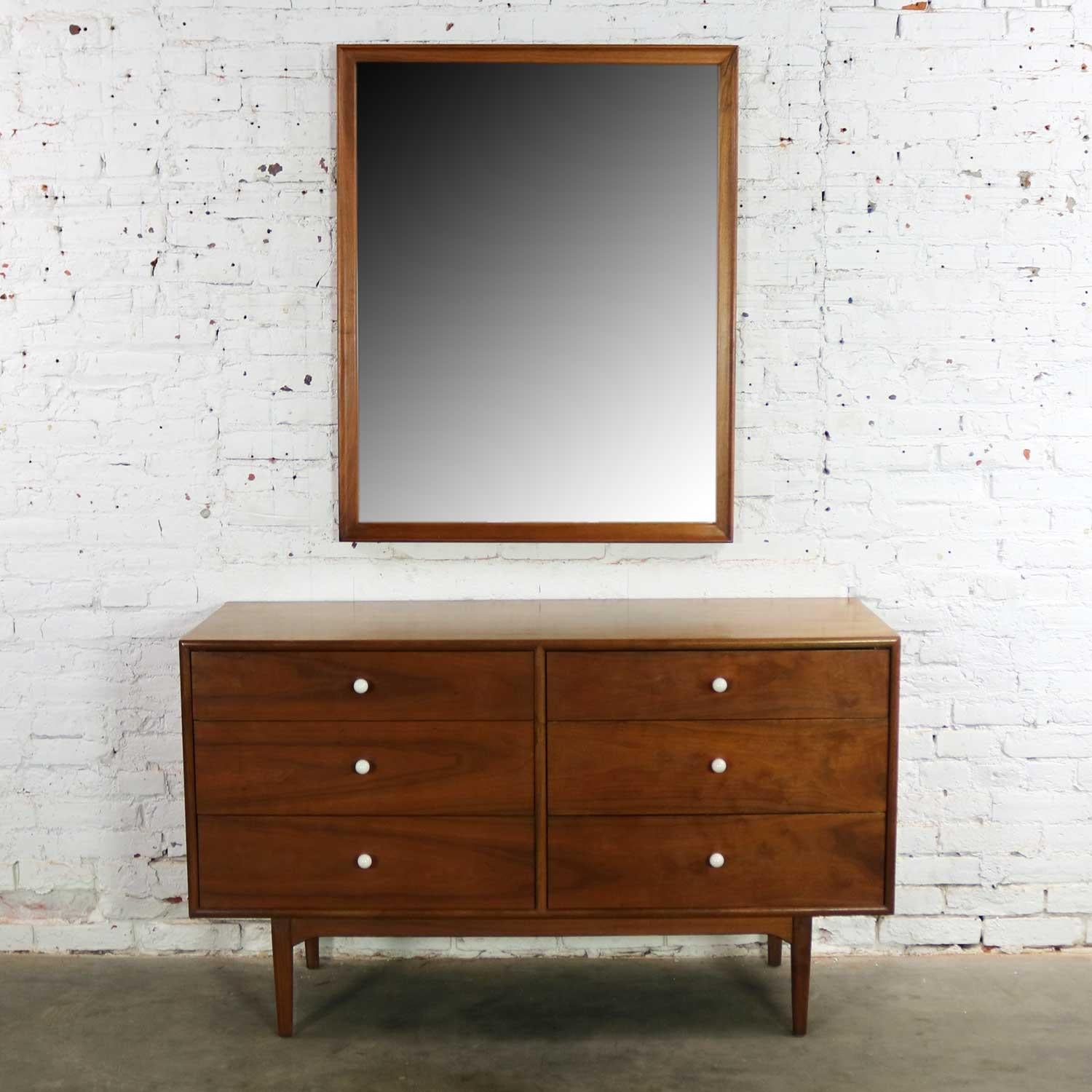 Handsome Mid-Century Modern walnut six-drawer dresser with mirror by Drexel from their Declaration collection designed by Kipp Stewart and Stewart MacDougall. It is in fabulous vintage condition overall. There is normal patina for its age and use.