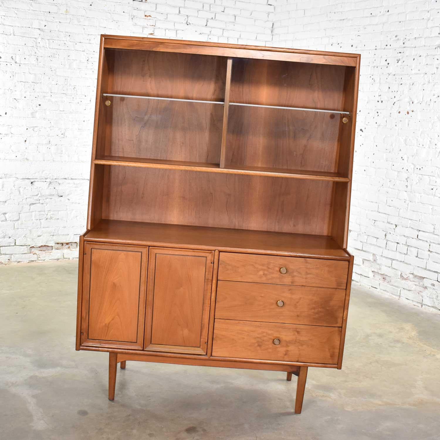 Handsome Mid-Century Modern walnut china hutch cabinet with glass upper doors by Kipp Stewart and Stewart MacDougall. It is in fabulous vintage condition overall. There is normal patina for its age and use. This piece has been very well cared for.
