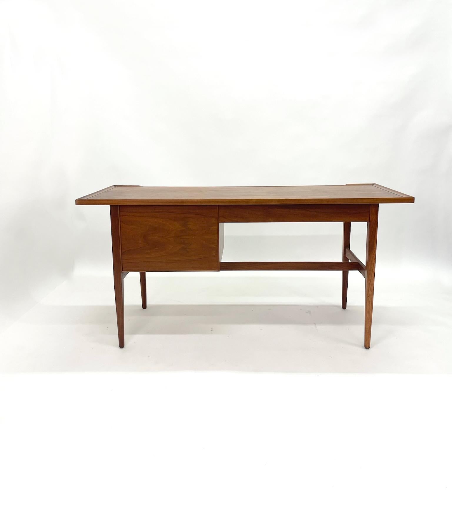 Designed by Kipp Stewart for Drexel with simple and sophisticated modern lines. Large file drawer and wide desk drawer, tapered legs, warm walnut grain. Stewart's design adds a nice sculpted lip around the edge. Finished on all sides. Completely