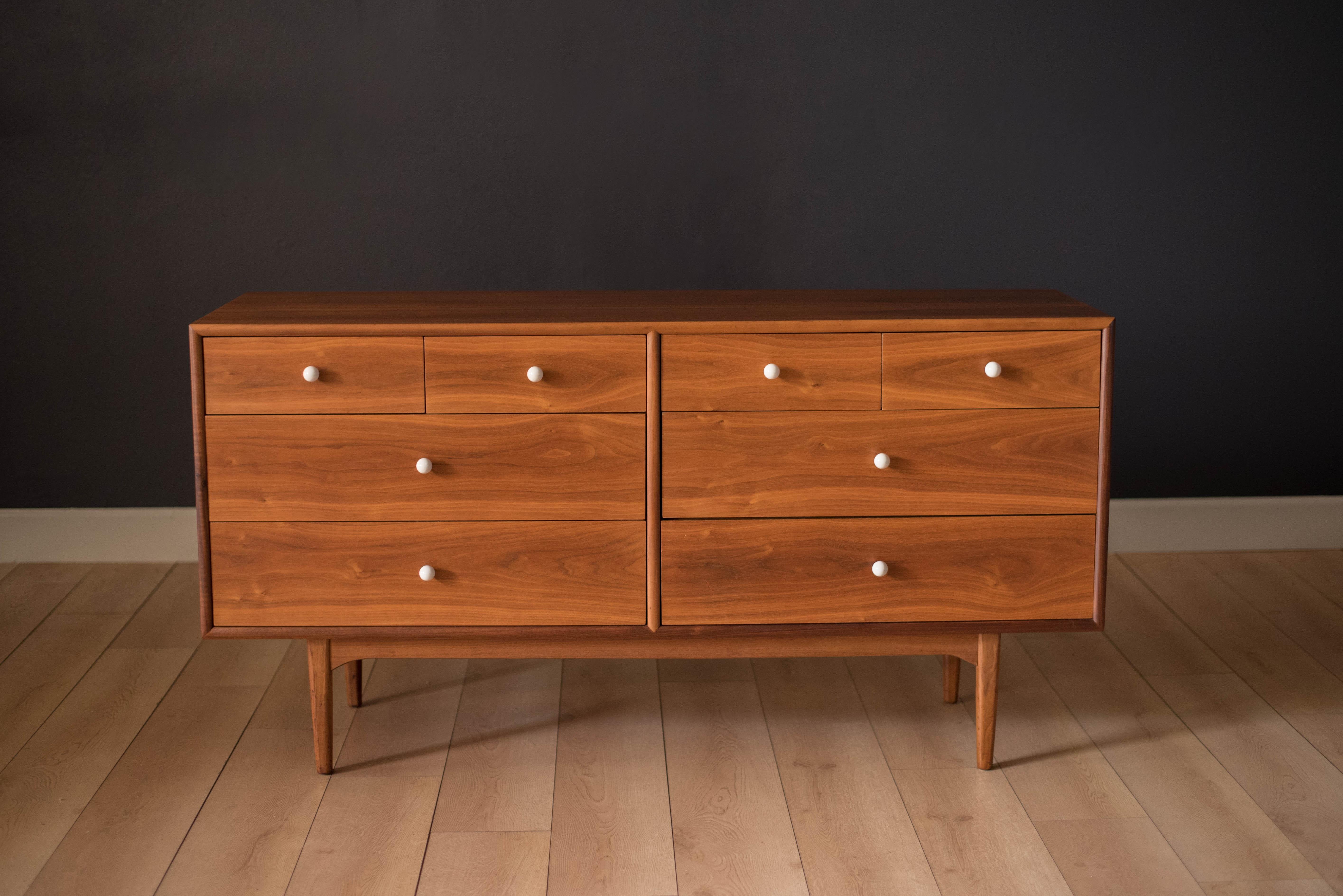 Mid century Drexel declaration low dresser by Kipp Stewart & Stewart McDougall. This piece features bookmatched black walnut grains equipped with the collection's signature porcelain knobs. Includes plenty of storage with eight dovetailed drawers.