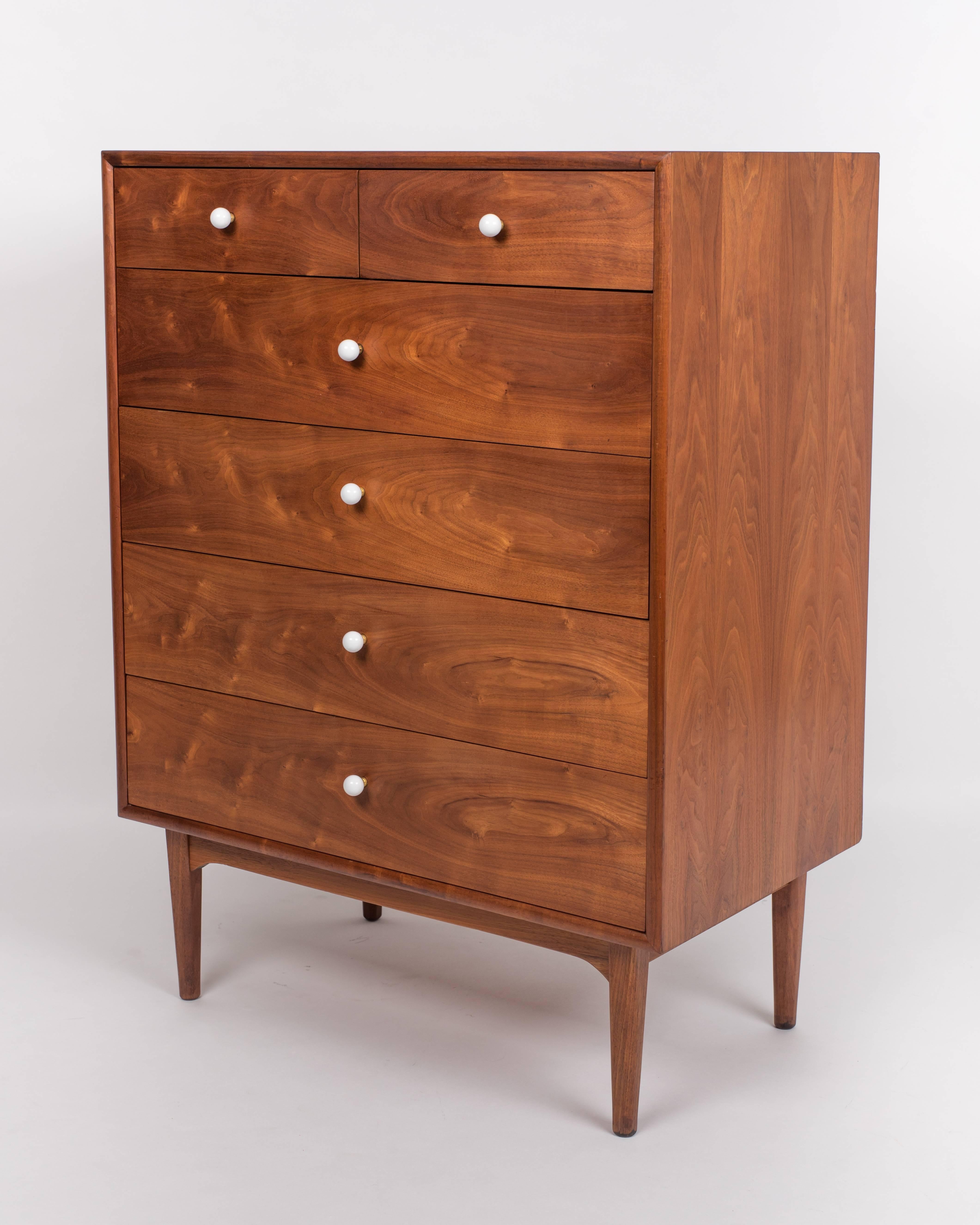 Walnut dresser from Drexel’s popular Declaration collection by Kipp Stewart and Stewart MacDougall. This example is a walnut case highboy style, holding six-drawers with original white ceramic knobs on brass spacers. The stacks has four large