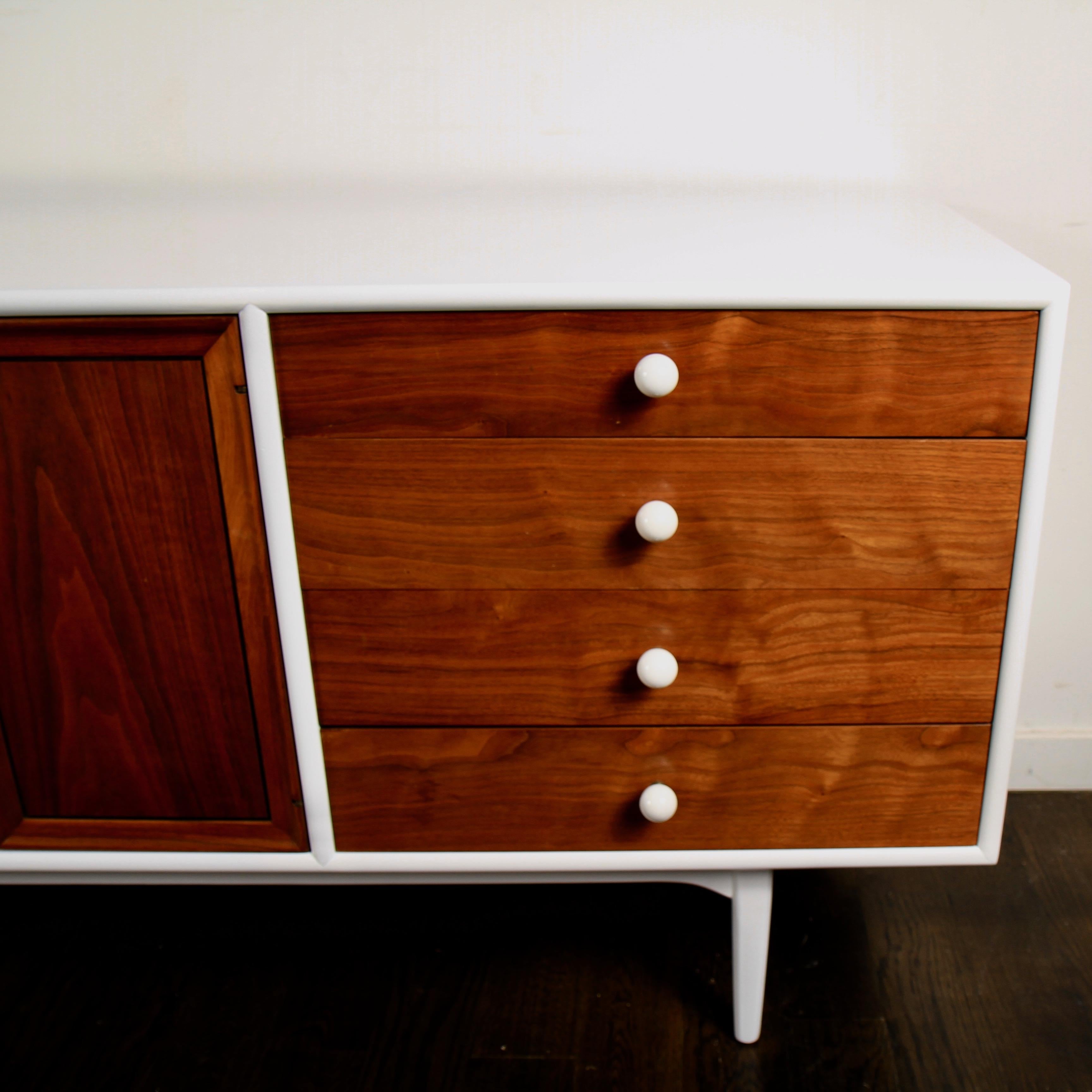 Classic midcentury low dresser designed by Kipp Stewart and Stewart MacDougall for Drexel. It's been updated with a white lacquered frame that contrasts nicely with the original white porcelain knobs.