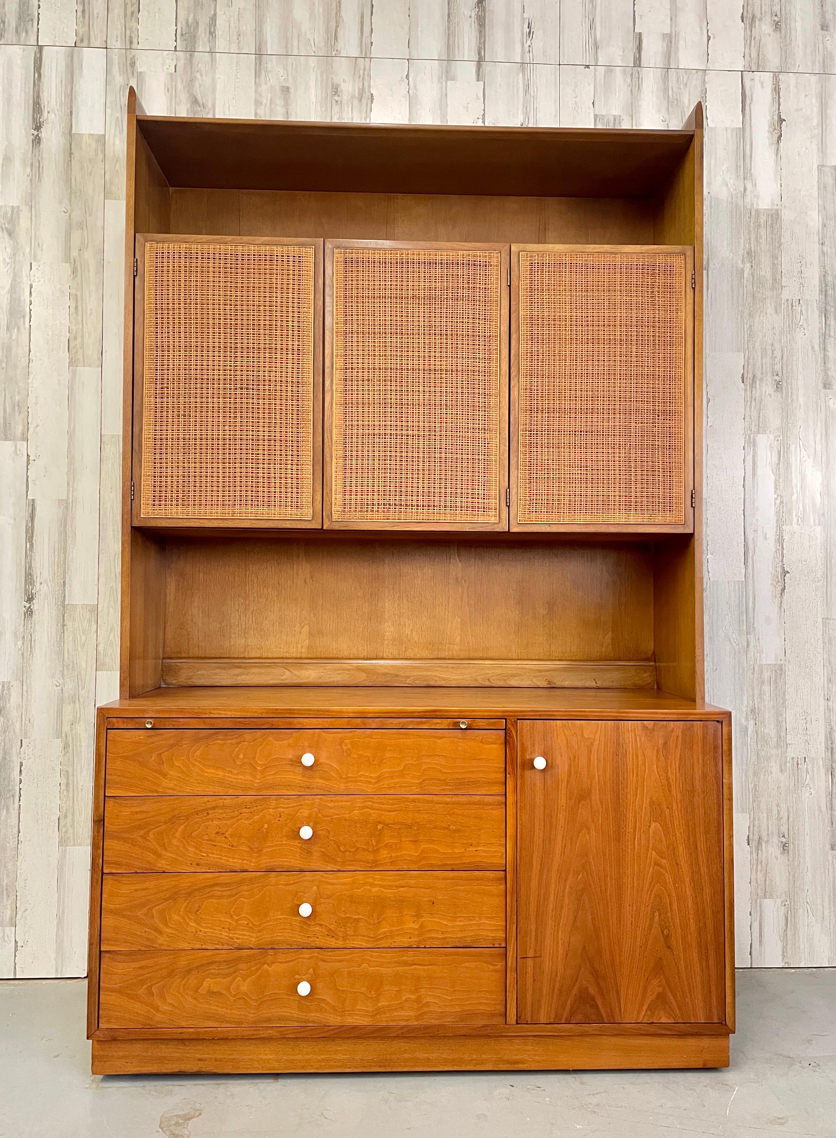 Drexel declaration walnut & cane cabinet designed by Stewart MacDougall and Kipp Stewart. Iconic design with walnut and cane- which is very rare to find. Multiple drawers for storage and hidden pull out top desk. Perfect for small apartments that