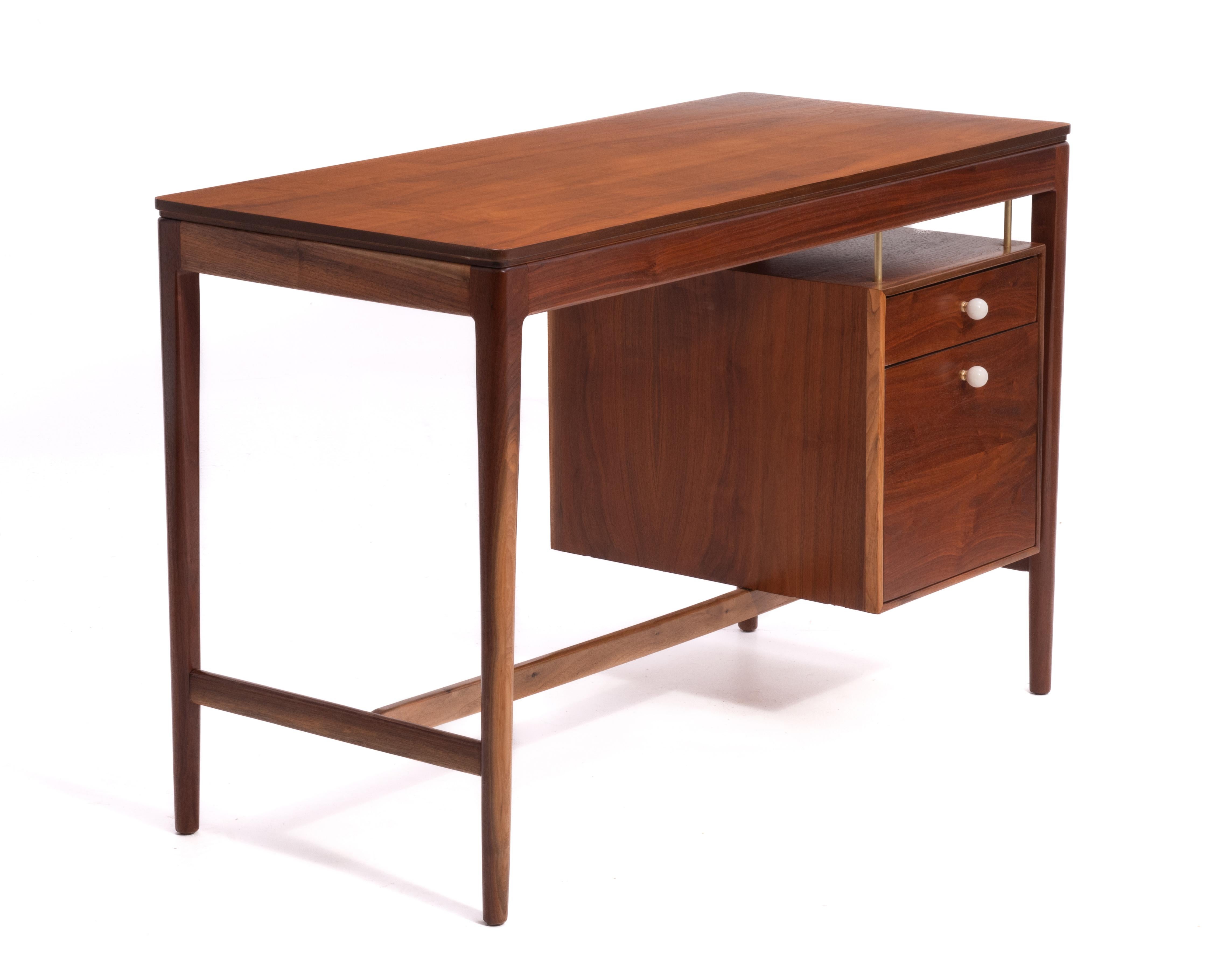 A Drexel Declaration writing desk designed by Kipp Stewart, signed on the underside. Floating drawers with brass and wood dowels, original hardware. Professionally restored with great depth and clarity to the walnut wood. 
The knee hole height is