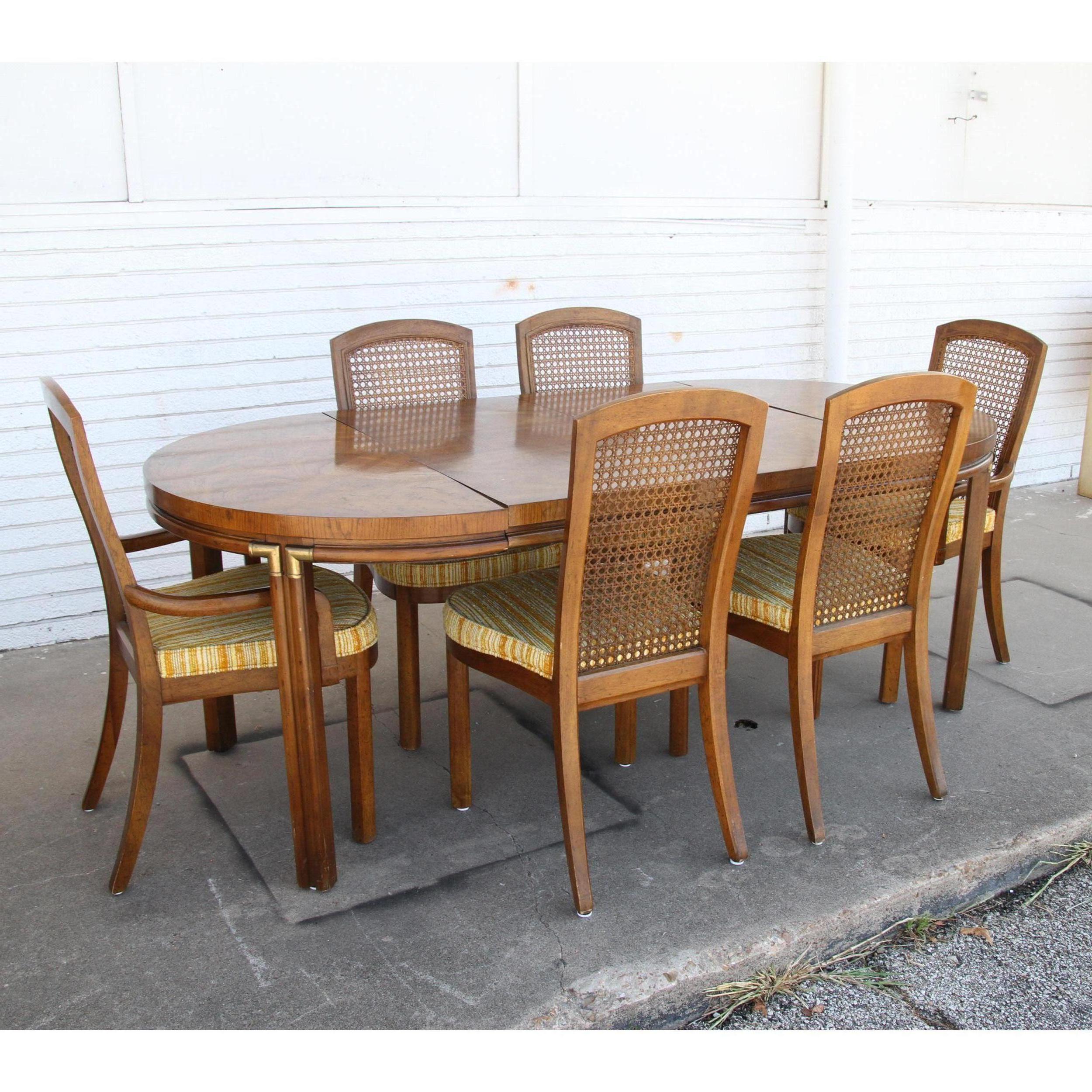 This is a handsome Drexel dining set that displays brass accents on the curves. It's also expandable and has leaves, so you can alter it's size for everyday use or extend it when entertaining company. 

There are 6 matching chairs available as seen