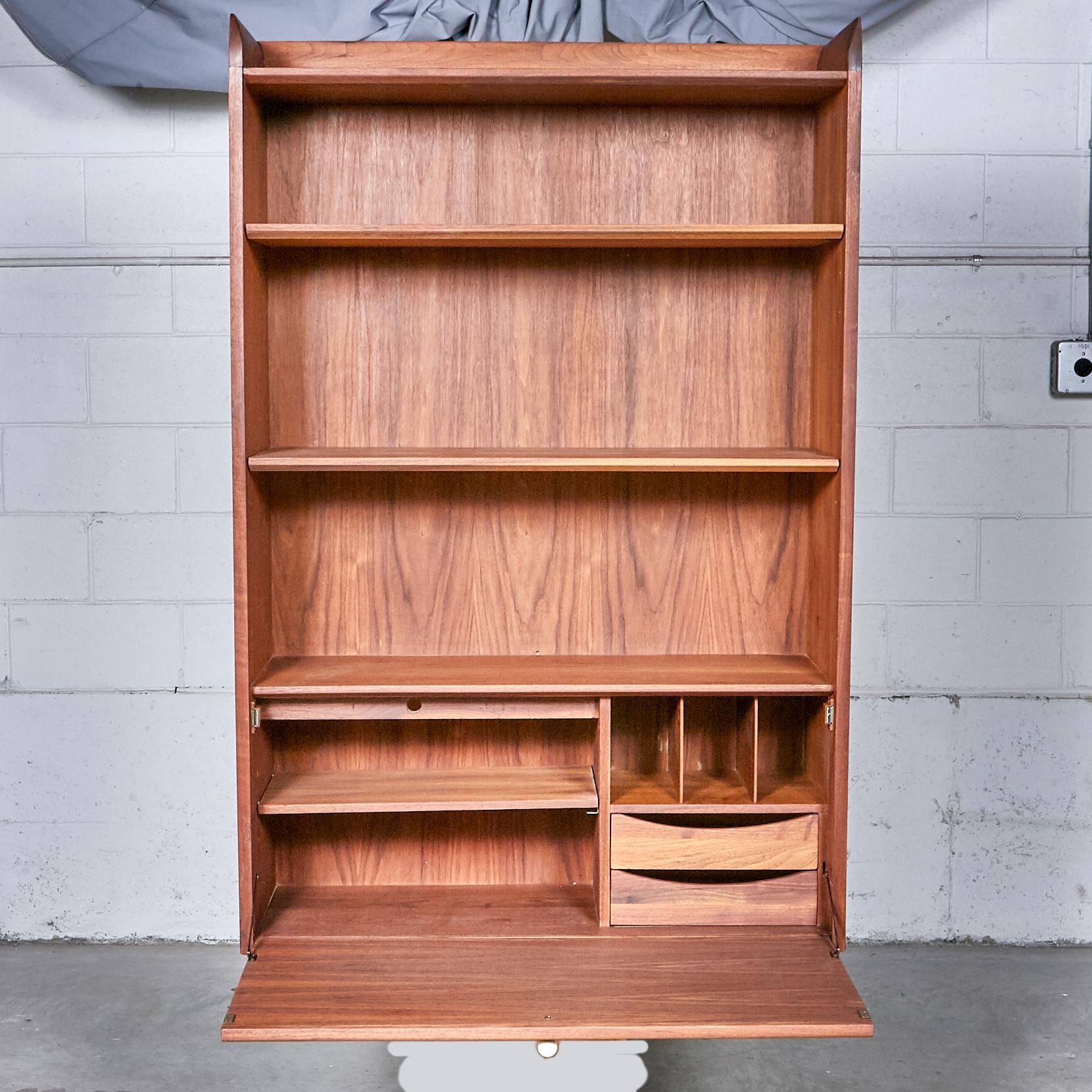 Vintage 1960s walnut floating wall cabinet designed by Kipp Stewart for Drexel Furniture Co. The top of the cabinet has shelving and the bottom is a writing desk with shelves and drawers for storage. Hardware to hang the shelf is included. Marked.
