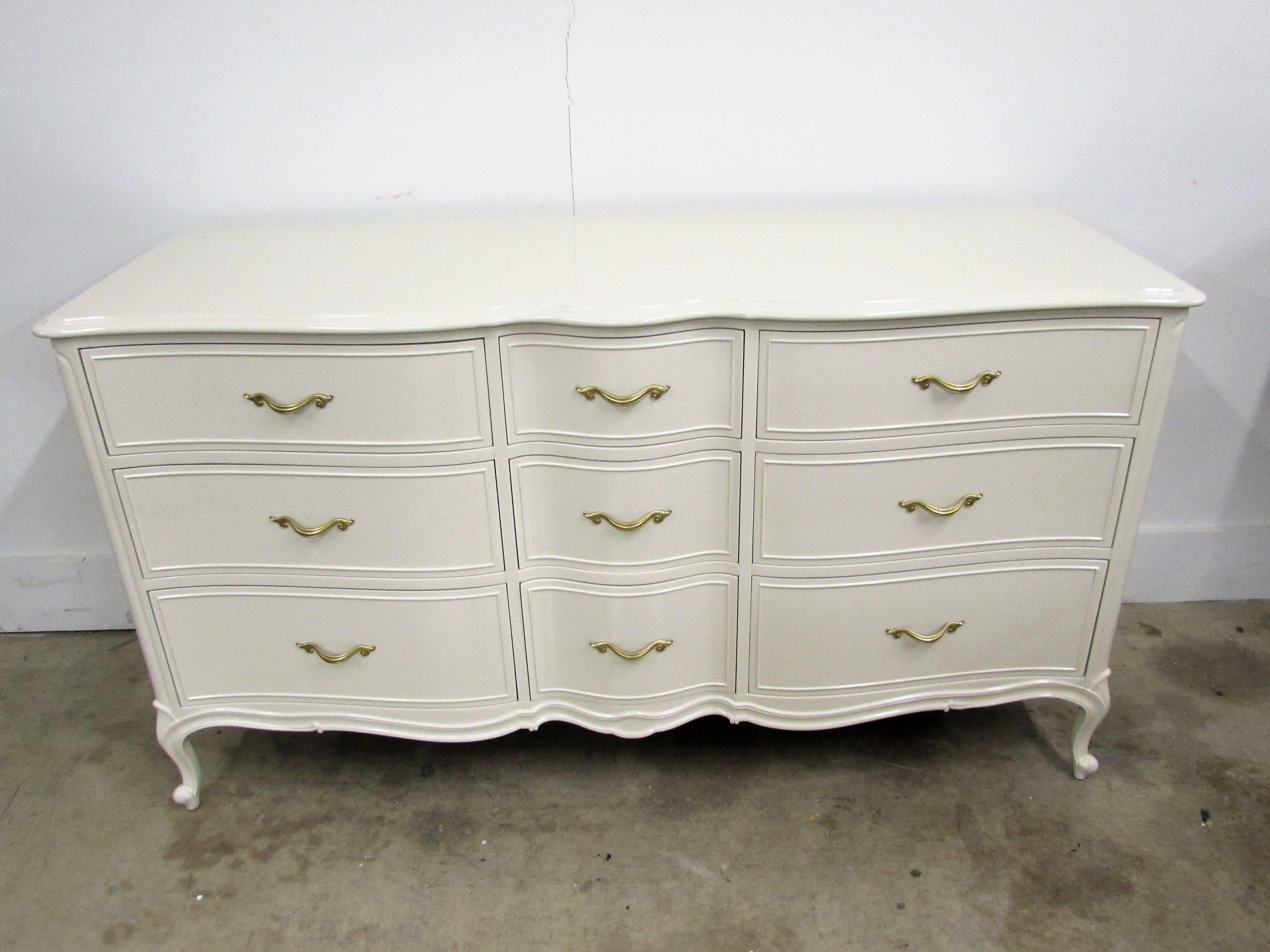 Drexel French chest of nine dovetail drawers lacquered in-house in Benjamin Moore natural cream and original French hardware customized in our gold under brass.