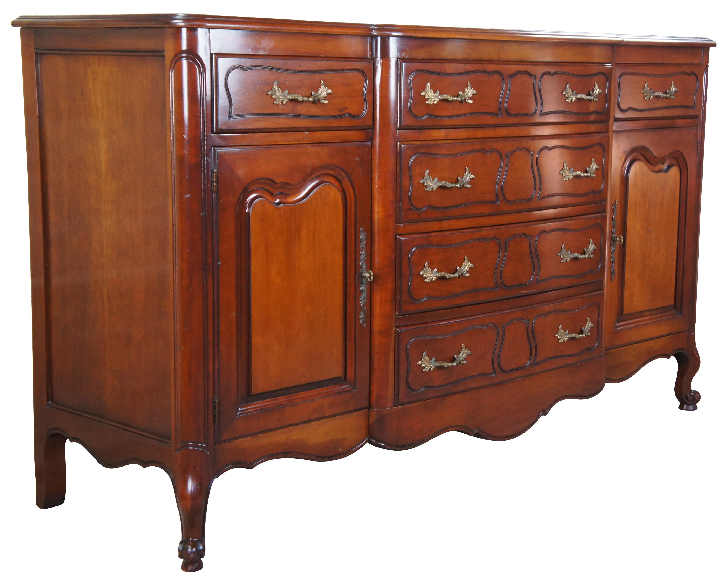 Vintage 1985 Drexel heritage French Provincial buffet or server. Made of cherry featuring rectangular form with a bowed front center of four drawers flanked by two more drawers and two cabinets, including one removable silverware tray with handles,