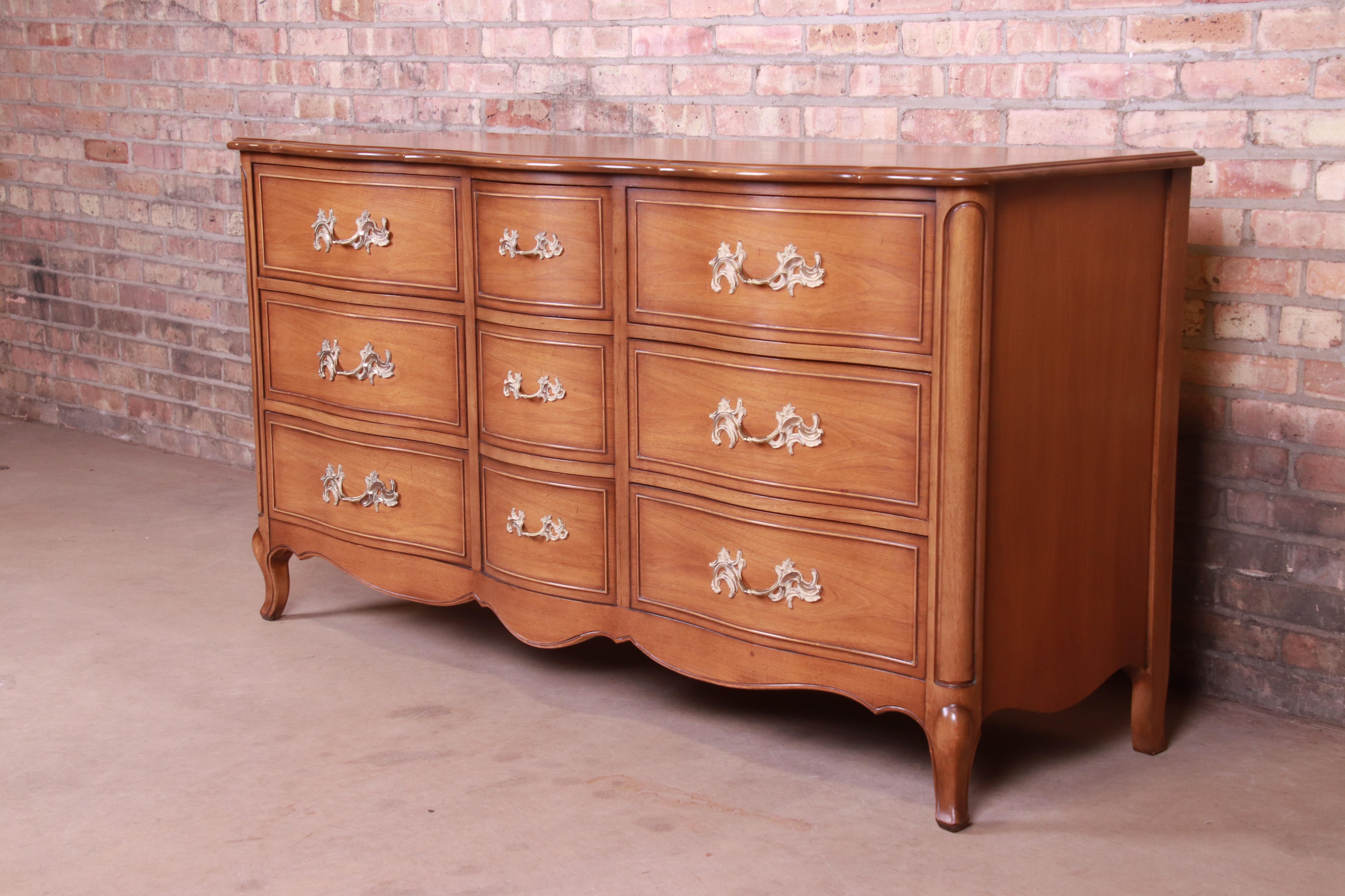 A gorgeous French Provincial Louis XV style nine-drawer dresser or credenza

By Drexel

USA, circa 1950s

Walnut, with original brass hardware.

Measures: 62.25