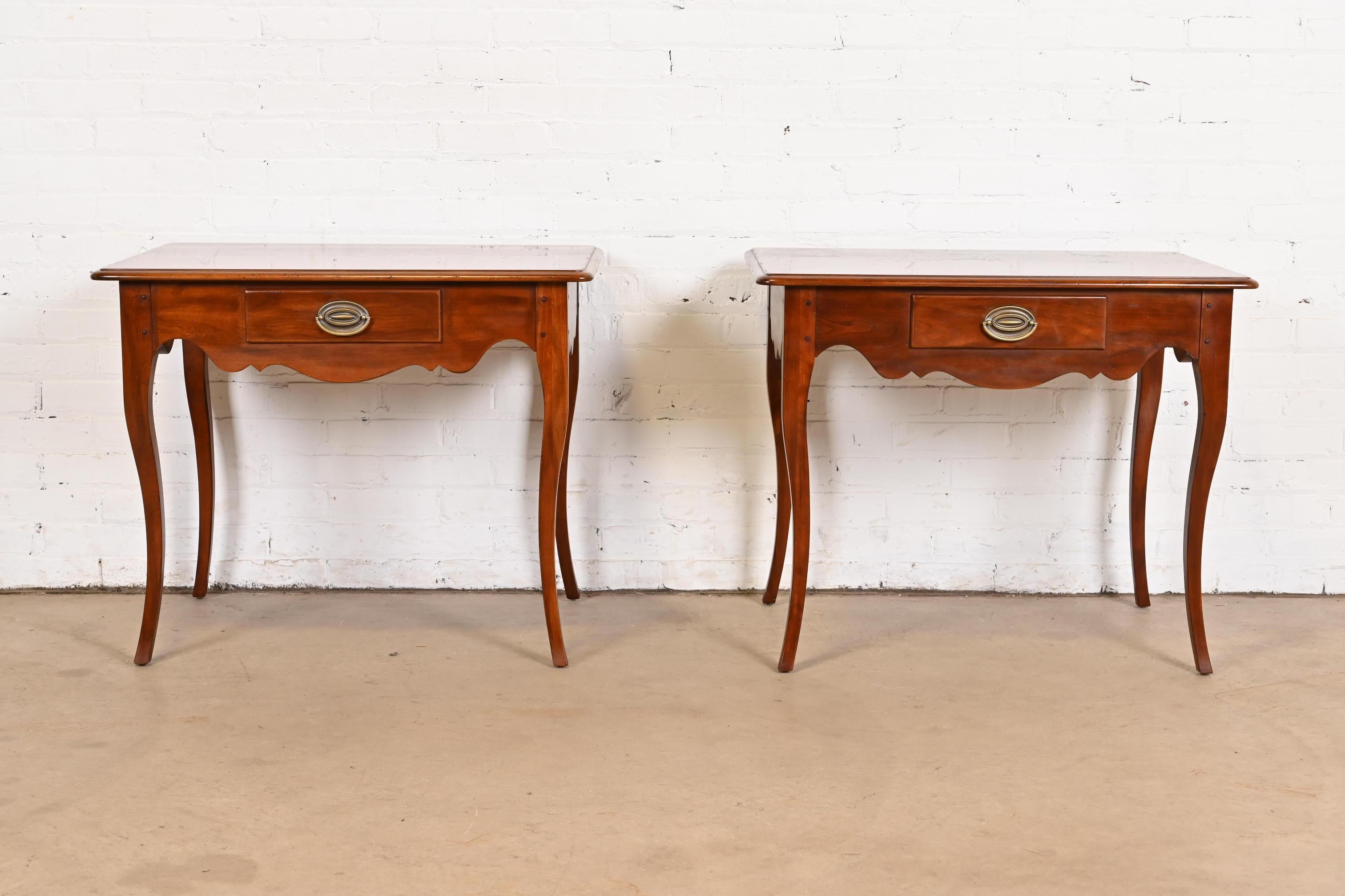 An exceptional pair of French Country or French Provincial Louis XV style nightstands or side tables.

By Drexel

USA, Circa Late 20th Century

Carved cherry wood, with original brass hardware.

Each measures: 38.25