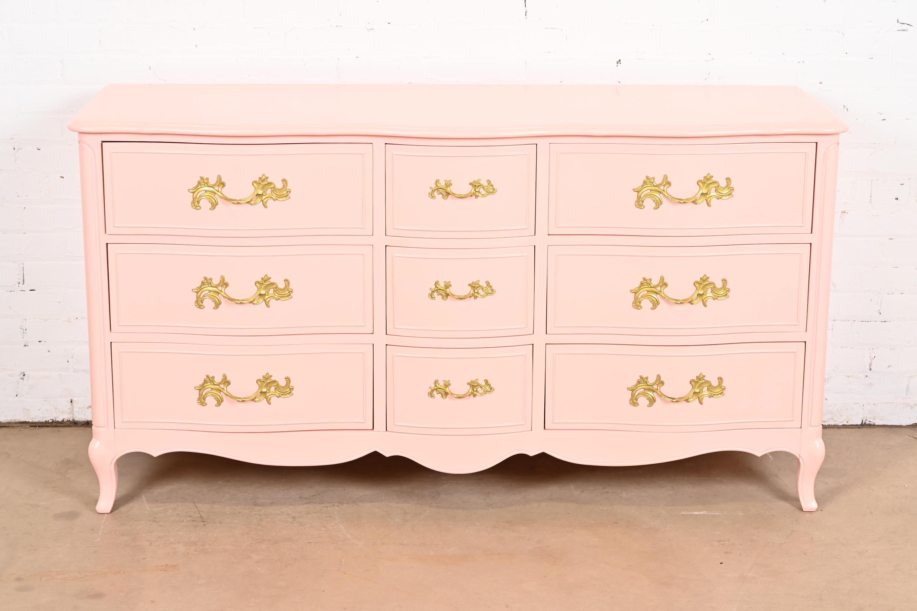 A gorgeous French Provincial Louis XV style nine-drawer triple dresser or credenza

By Drexel

USA, Circa 1960s

Pink lacquered cherry wood, with original brass hardware.

Measures: 62