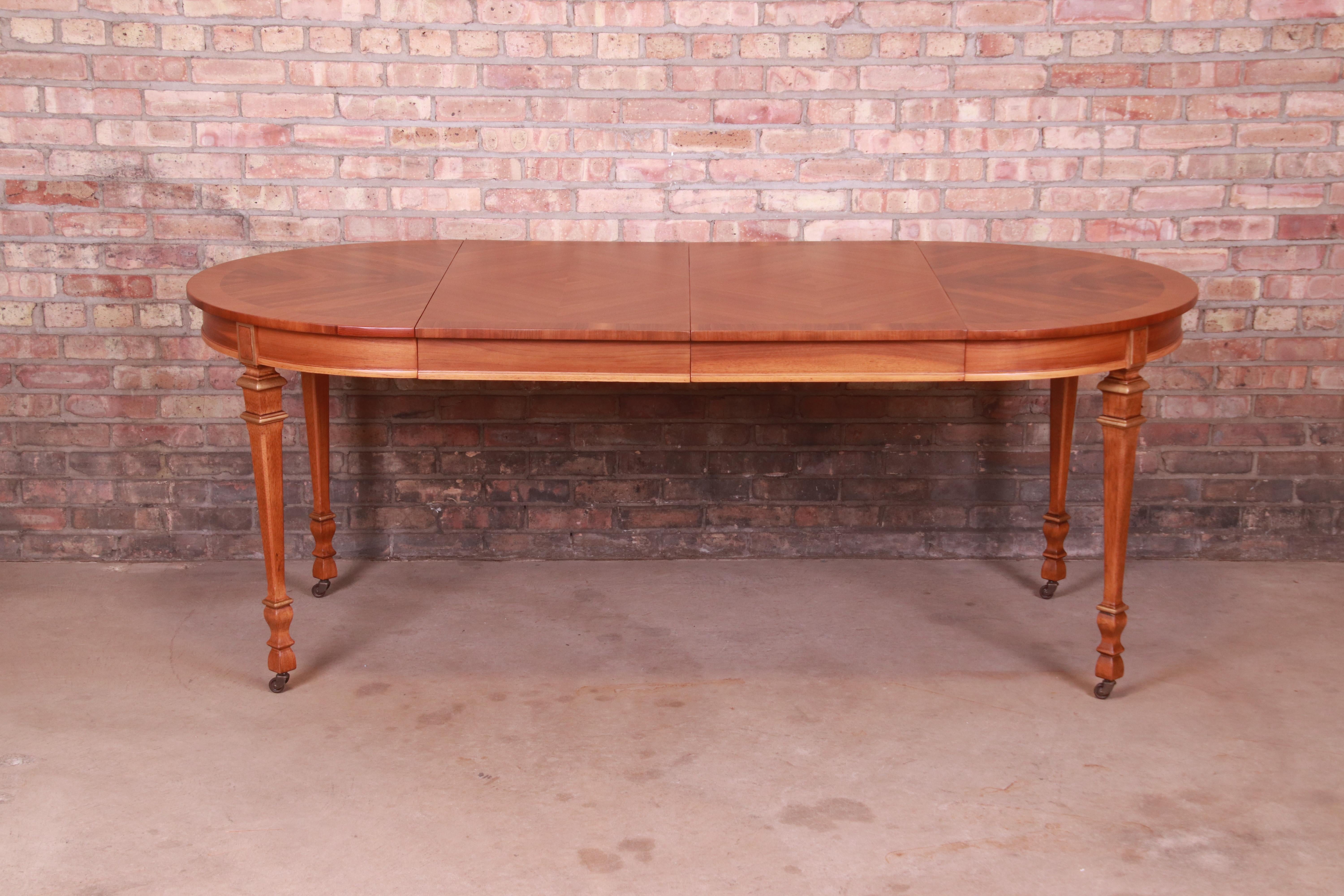 A gorgeous mid-century French Regency Louis XVI style extension dining table

By Drexel

USA, Mid-20th century

Book-matched walnut top, with carved walnut legs and gold gilt details.

Measures: 40