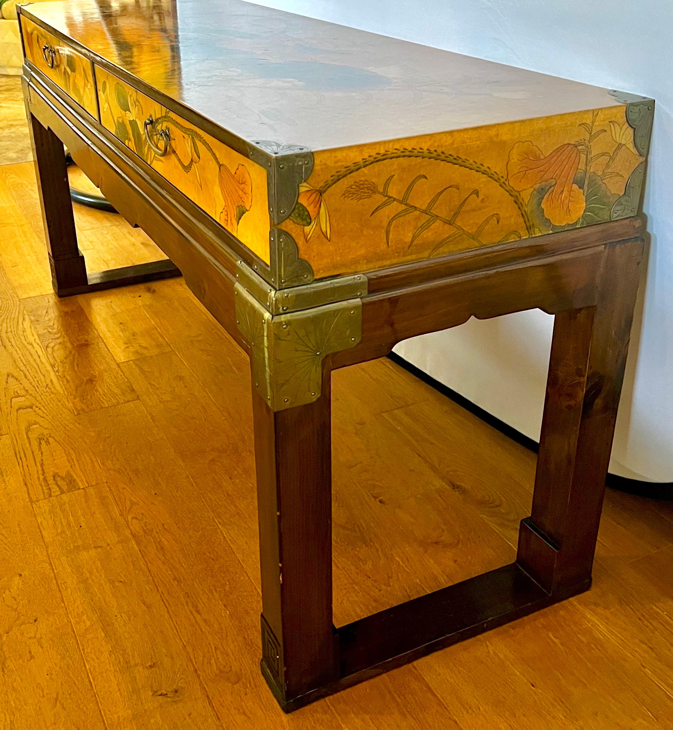 Coveted campaign style Drexel chinoiserie console table with elegant graphic scene and brass fittings.  Iconic mid century styling and lines to tie for.  Features drawers at front as shown