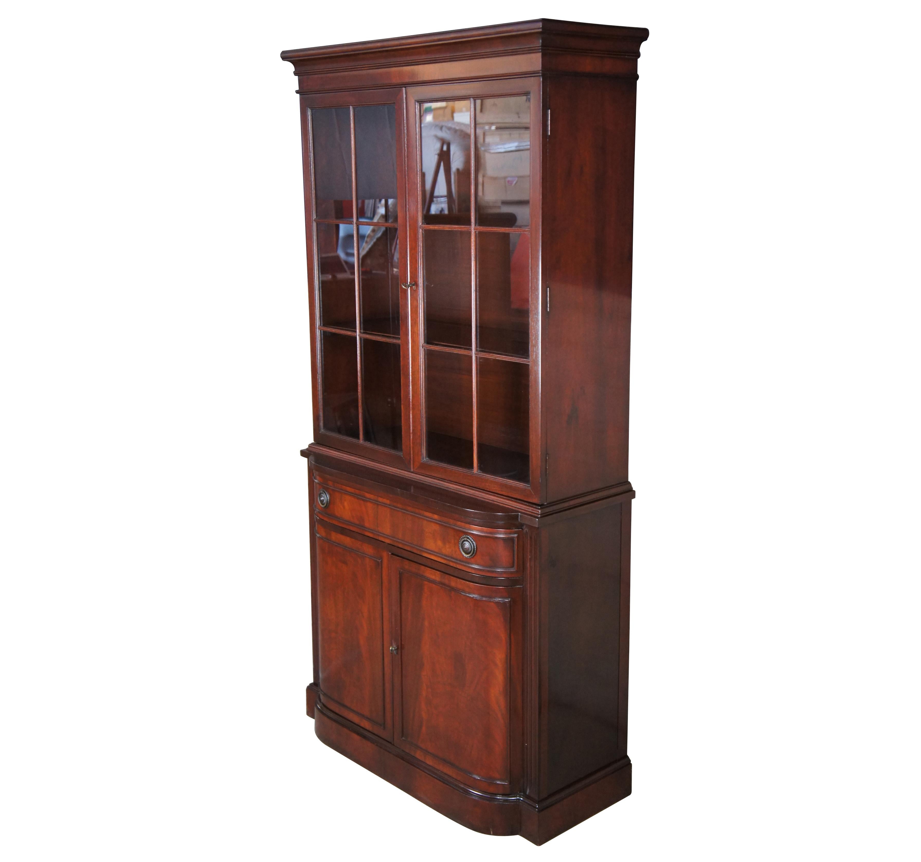 Vintage Drexel Georgian style bowfront china cabinet or cupboard, circa 1940s. Made of genuine mahogany featuring three upper shelves with plate grooves, over one drawer, and a lower cabinet. Lower cabinet and drawer fronts have a rich crotch /