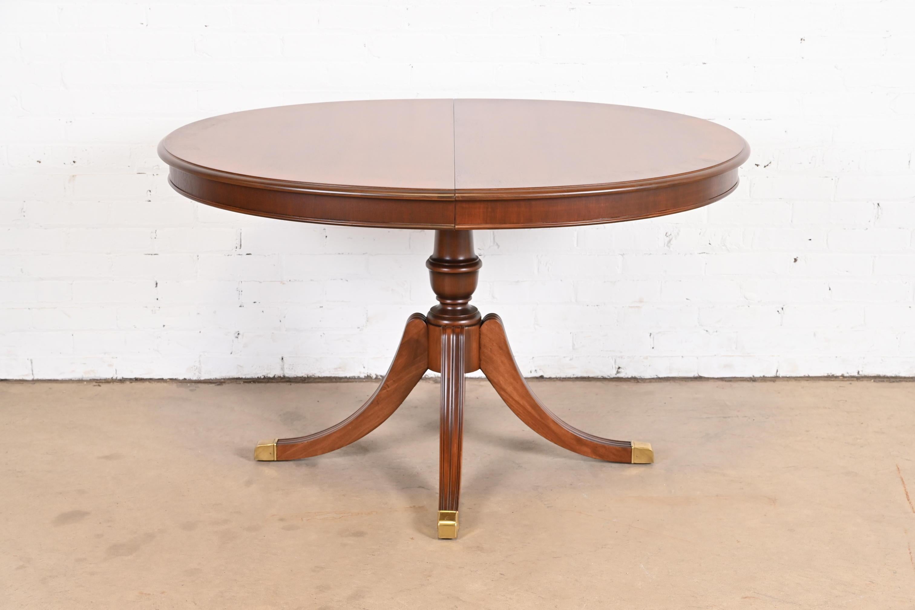 A beautiful Georgian or Regency style pedestal extension dining table

By Drexel

USA, Circa 1960s

Banded mahogany, with carved solid mahogany pedestal and brass-capped feet.

Measures: 50.25
