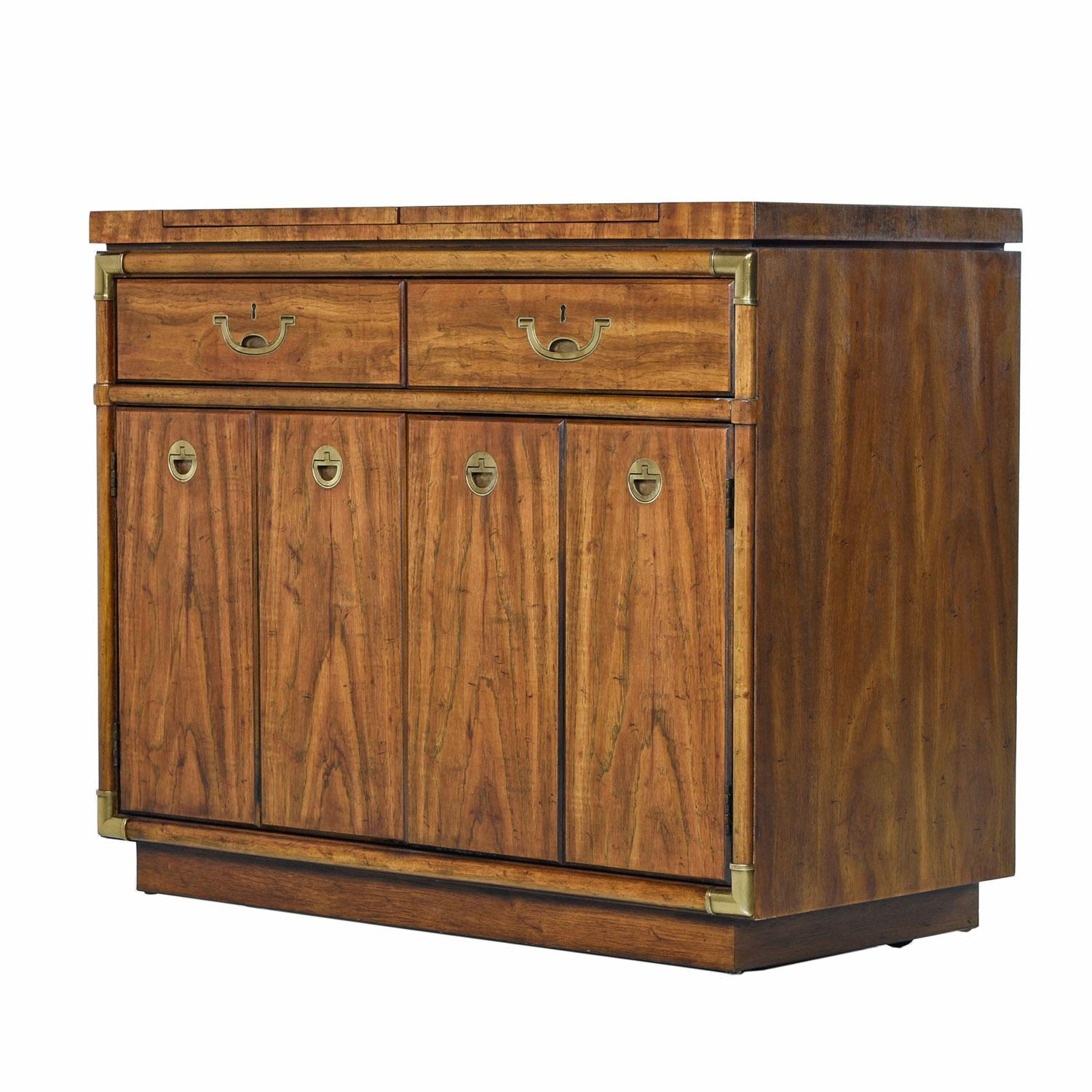 Dorothy Draper style campaign server bar cart on casters made by esteemed US furniture maker Drexel Heritage circa 1970s. Old growth flaxen flared grain pecan top to bottom. Beautifully finished on all four sides. Faux bamboo brass corner accents on