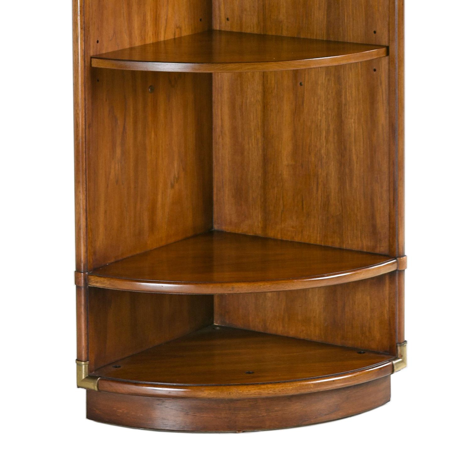 Solid wood Campaign style corner cabinet curio bookshelf made by esteemed US furniture maker Drexel Heritage in the 1970s. Faux bamboo brass corner accents on all four corners tie together British traditional and Eastern design. This tall cabinet