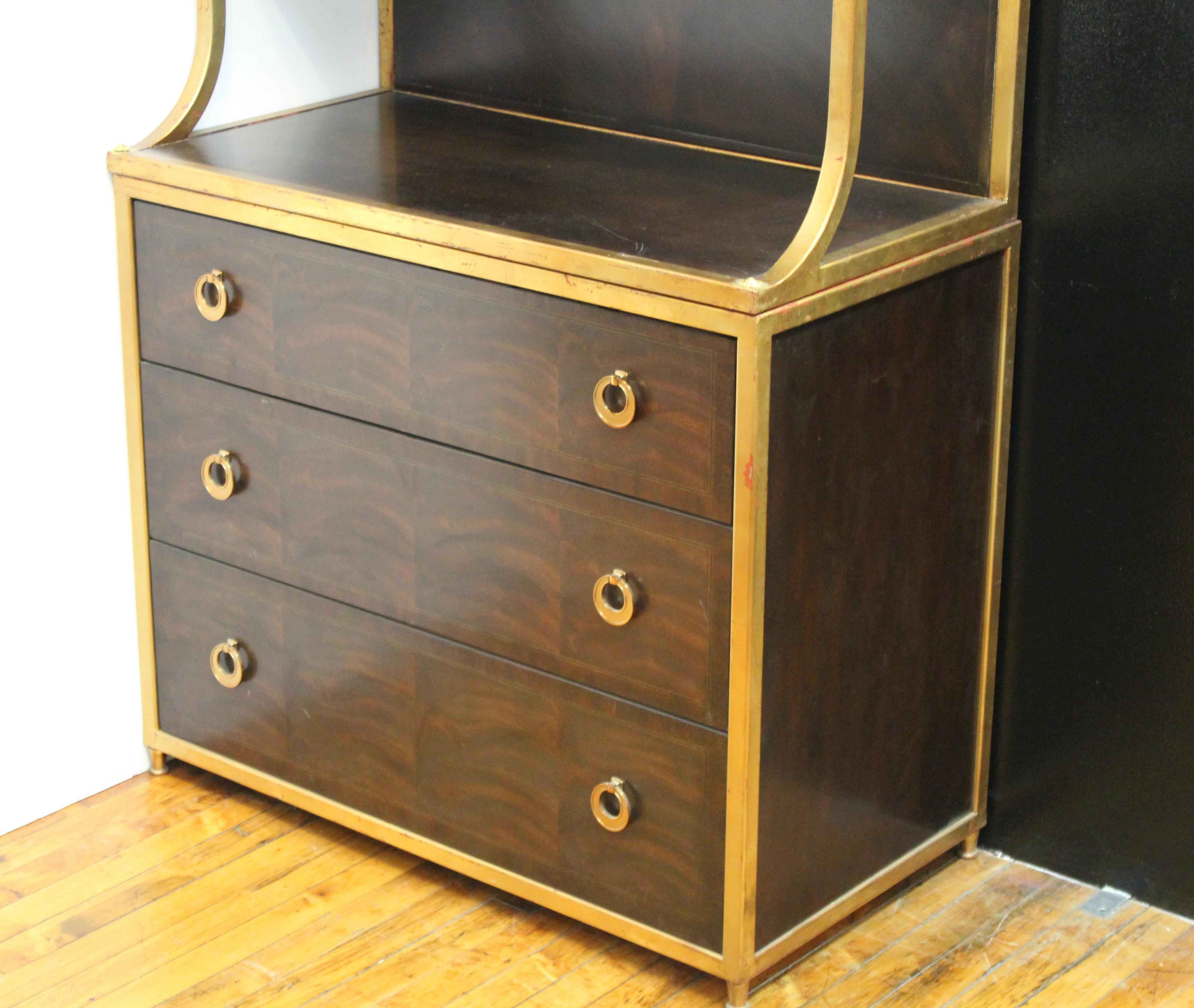Drexel Heritage Art Deco style étagère and cabinet in mahogany wood and partially gilt surfaces. The piece has four levels of open shelving, which rest atop a chest of three drawers with gilt pulls. Makers plaque inside top drawer. In great vintage