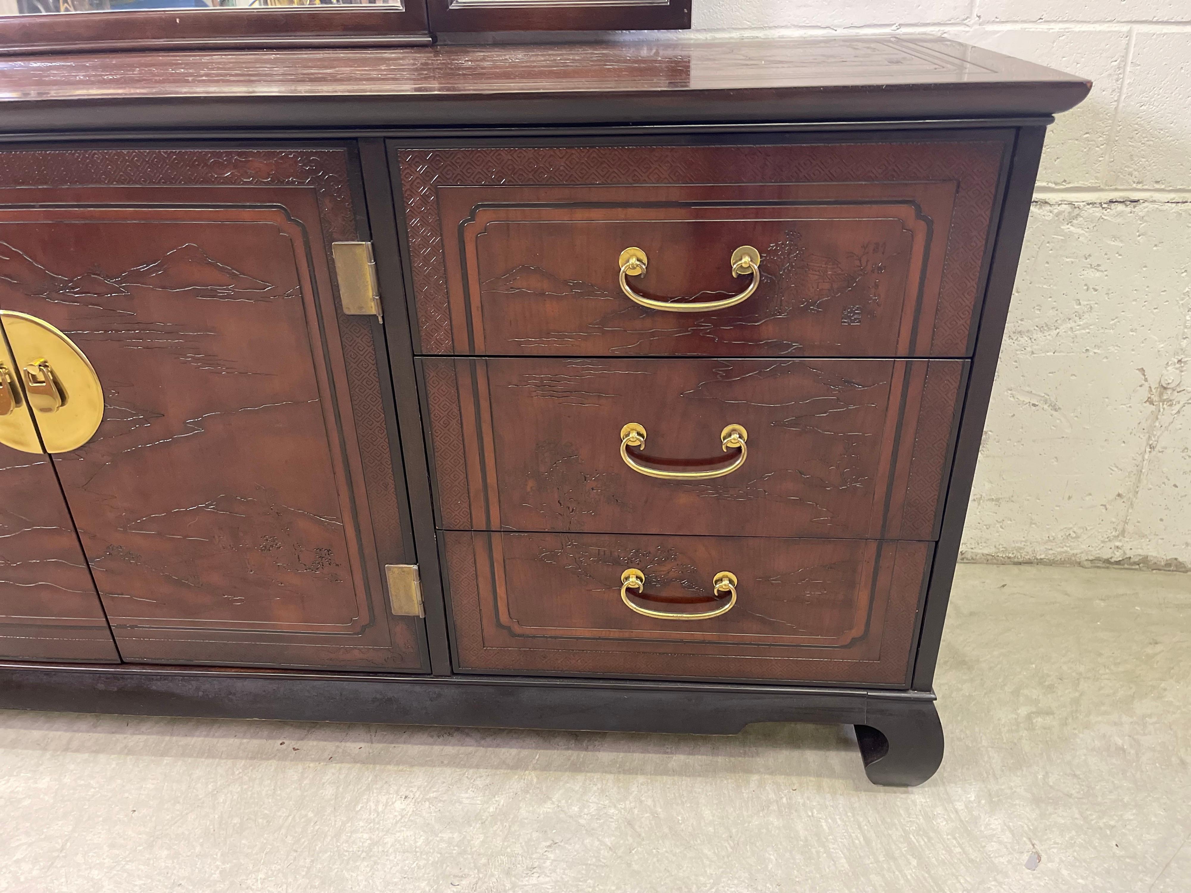 Vieille commode longue de style asiatique sculptée de Drexel Heritage avec miroir. La commode fait partie de la ligne Connoisseur. Il comporte neuf tiroirs de rangement avec des poignées en laiton. L'ensemble de la commode et du miroir est sculpté