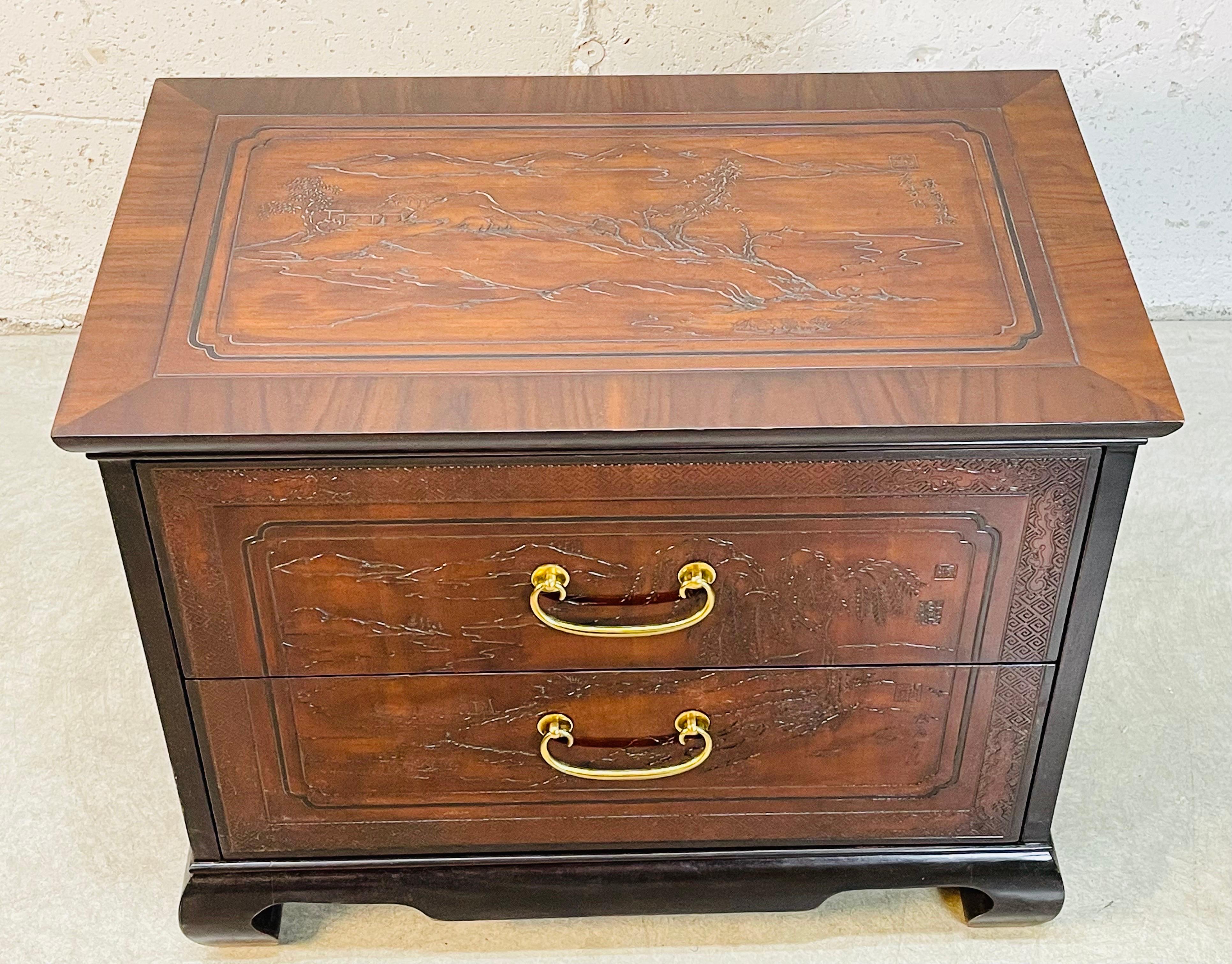 Vintage 1980s Drexel Heritage Asian style nightstand. The nightstand has two drawers for storage. The drawers are 4.75”H each. The dresser has solid brass pulls. The Asian scenes cover the top, front and both sides. Marked.