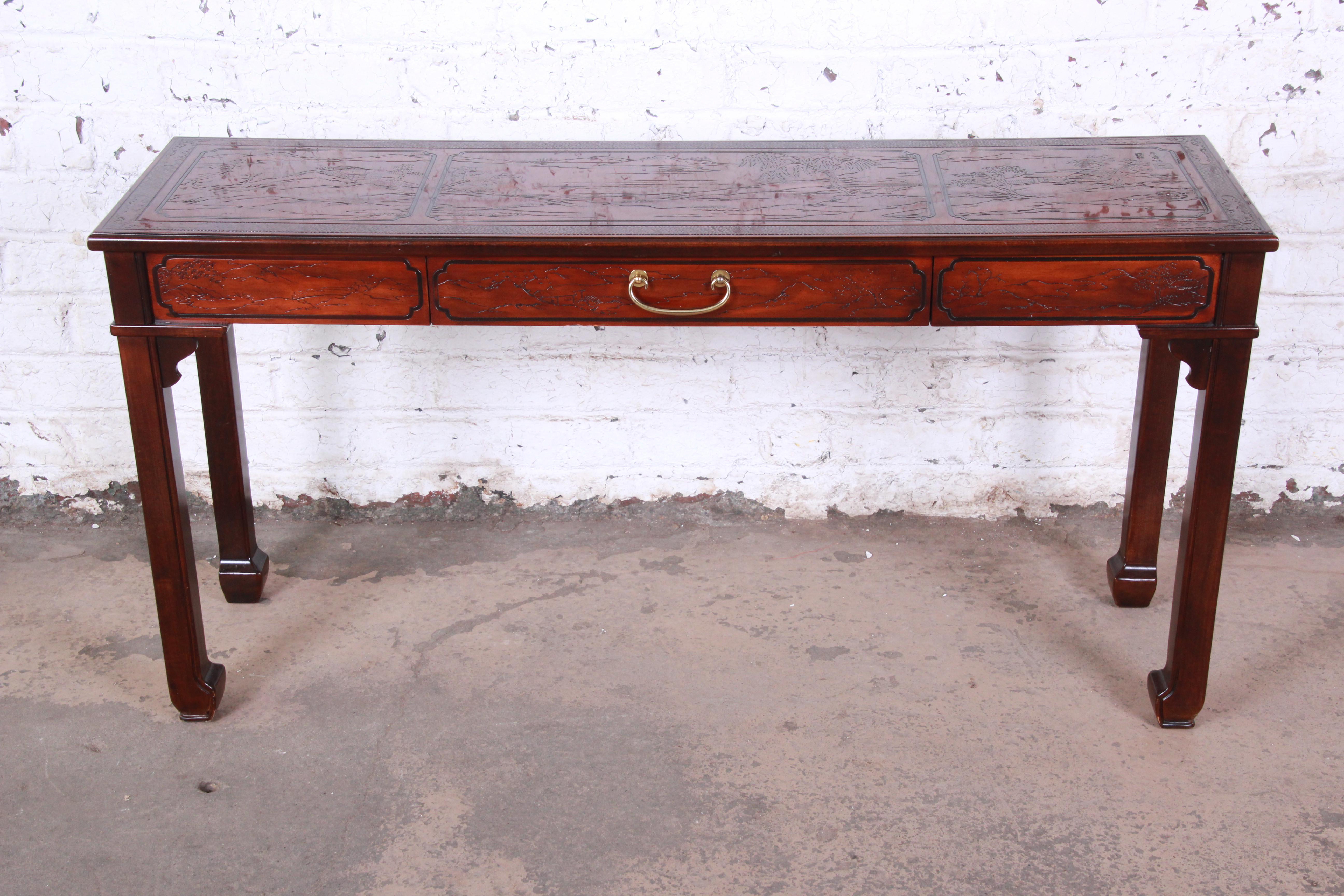 An exceptional Hollywood Regency Chinoiserie console or sofa table from the Conoisseur line by Drexel Heritage. The table features beautiful mahogany wood grain and unique carved Asian details with nature scenes. It has a single drawer with original
