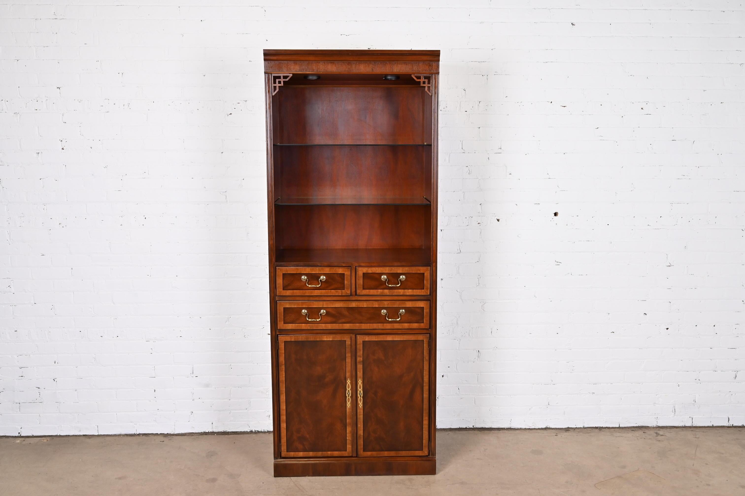 A gorgeous Chippendale or Georgian style lighted bookcase or display cabinet

By Drexel Heritage

USA, Circa 1980s

Mahogany, with satinwood banding and original brass hardware.

Measures: 31.5