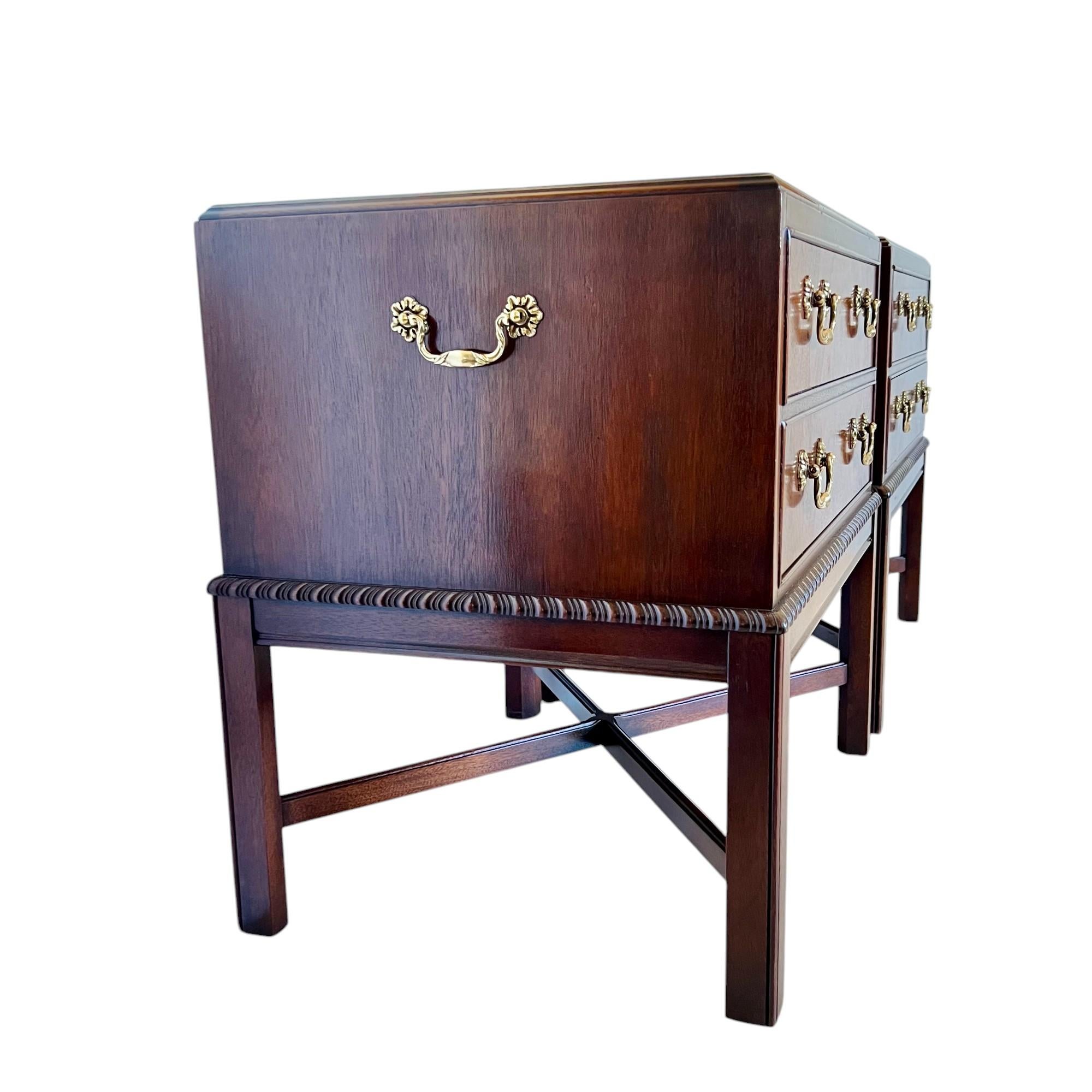 A vintage pair of traditional mahogany two-drawer nightstands or accent chests by Drexel Heritage from the Heirloom collection of the 1980's. These gorgeous storage pieces are finished on all sides and feature flame mahogany burl wood drawer faces