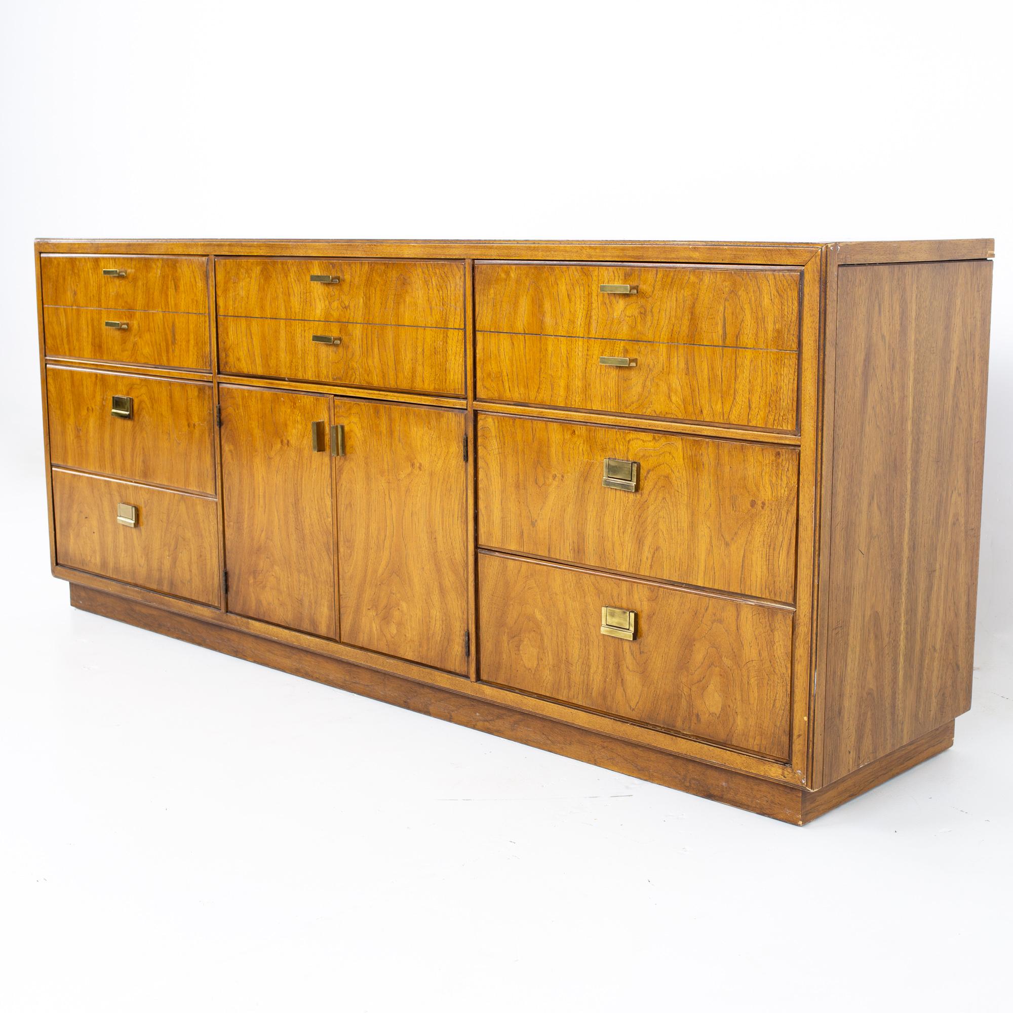 Drexel heritage consensus mid century pecan and brass 9 drawer lowboy dresser.
La commode mesure : 72 de large x 18.75 de profond x 30.5 de haut.