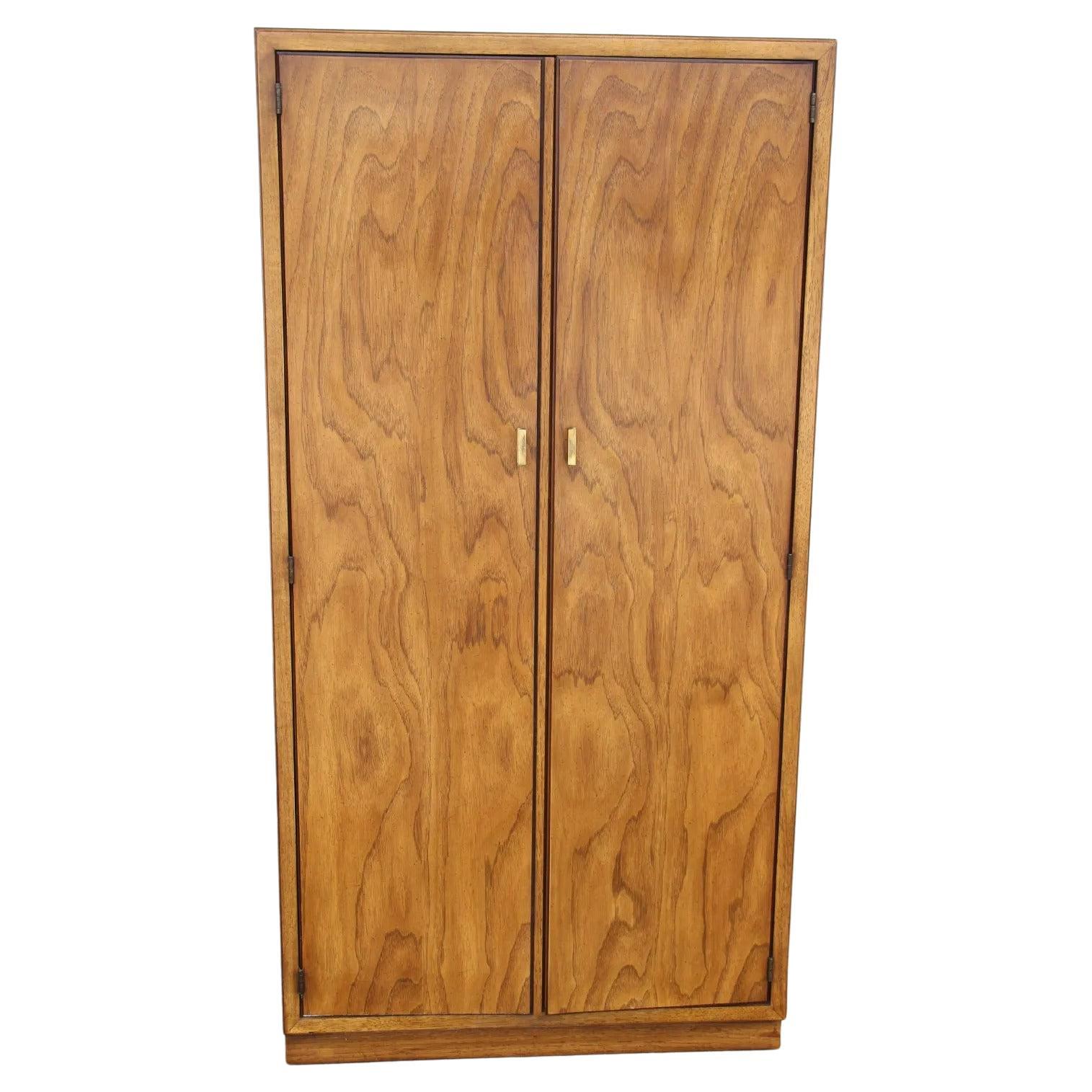 Dry bar cabinet by Drexel Heritage Consensus 

Flaxen pecan with a mirror back. Pull-out hidden laminated shelf sits concealed on top of the pull-out drawer. Adjustable glass shelves on top and bottom compartments. Lighted overhead interior.
  