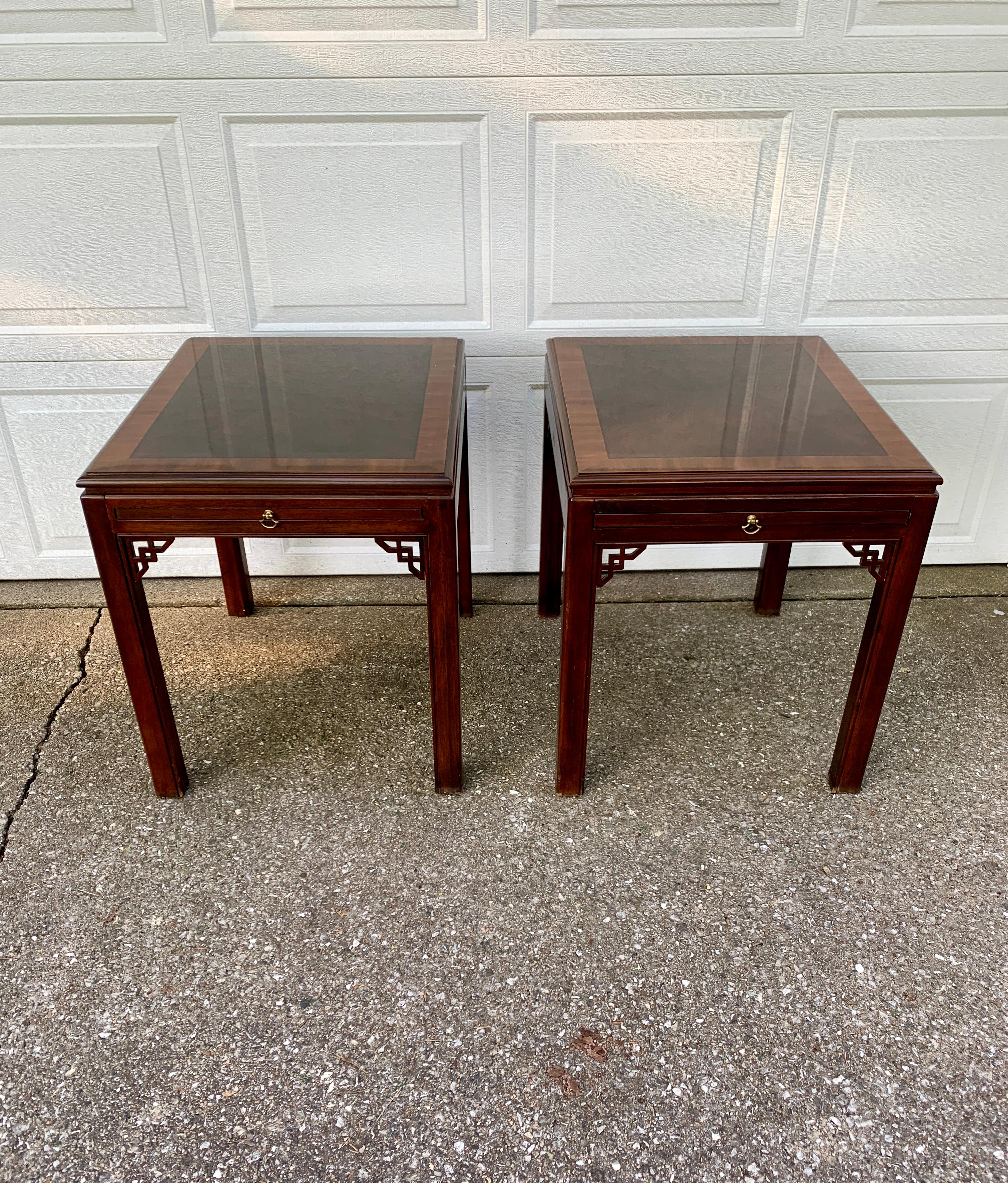 A stunning pair of English Chippendale or Georgian style side or end tables with pull-out trays

By Drexel Heritage

USA, Circa 1980s

Carved mahogany, with banded mahogany tops, and brass hardware

Measures: 22