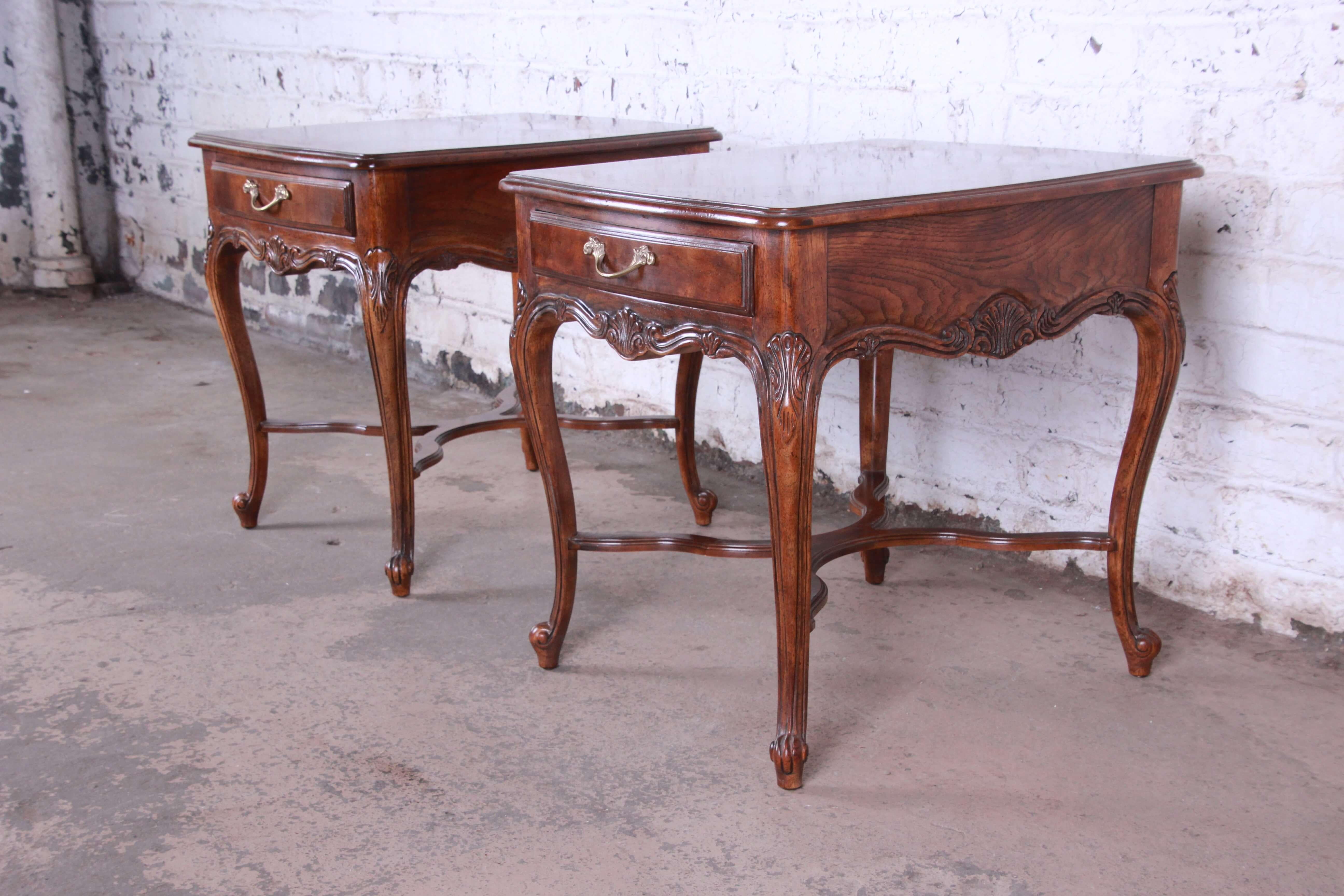 Offering a nice pair of Drexel Heritage French parquetry end table. The walnut tables have nice brass hardware with each table have a smooth sliding drawer for storage. The top of the tables have a nice parquetry design and nice French details