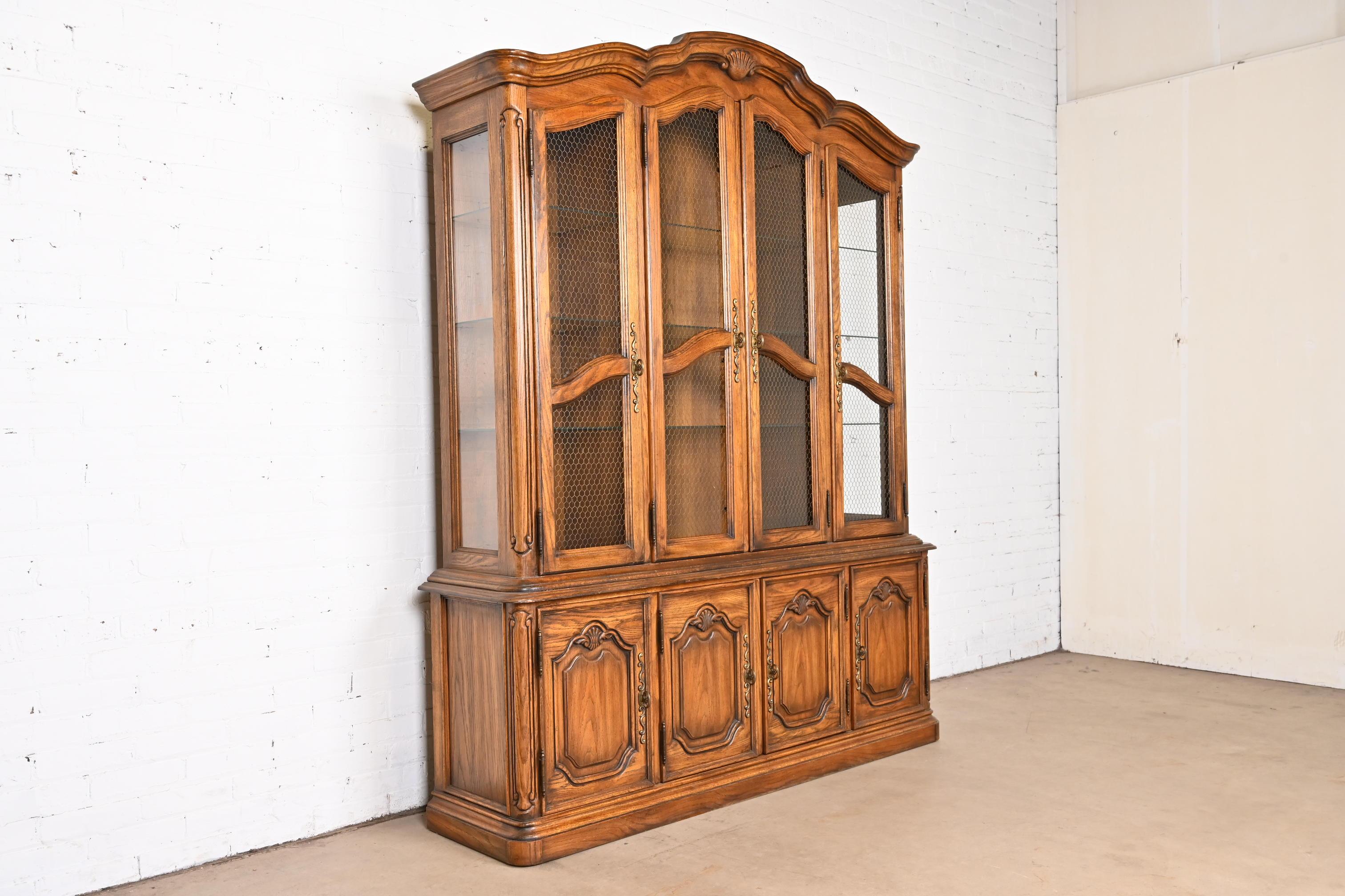 Late 20th Century Drexel Heritage French Provincial Carved Oak Lighted Breakfront Bookcase Cabinet For Sale