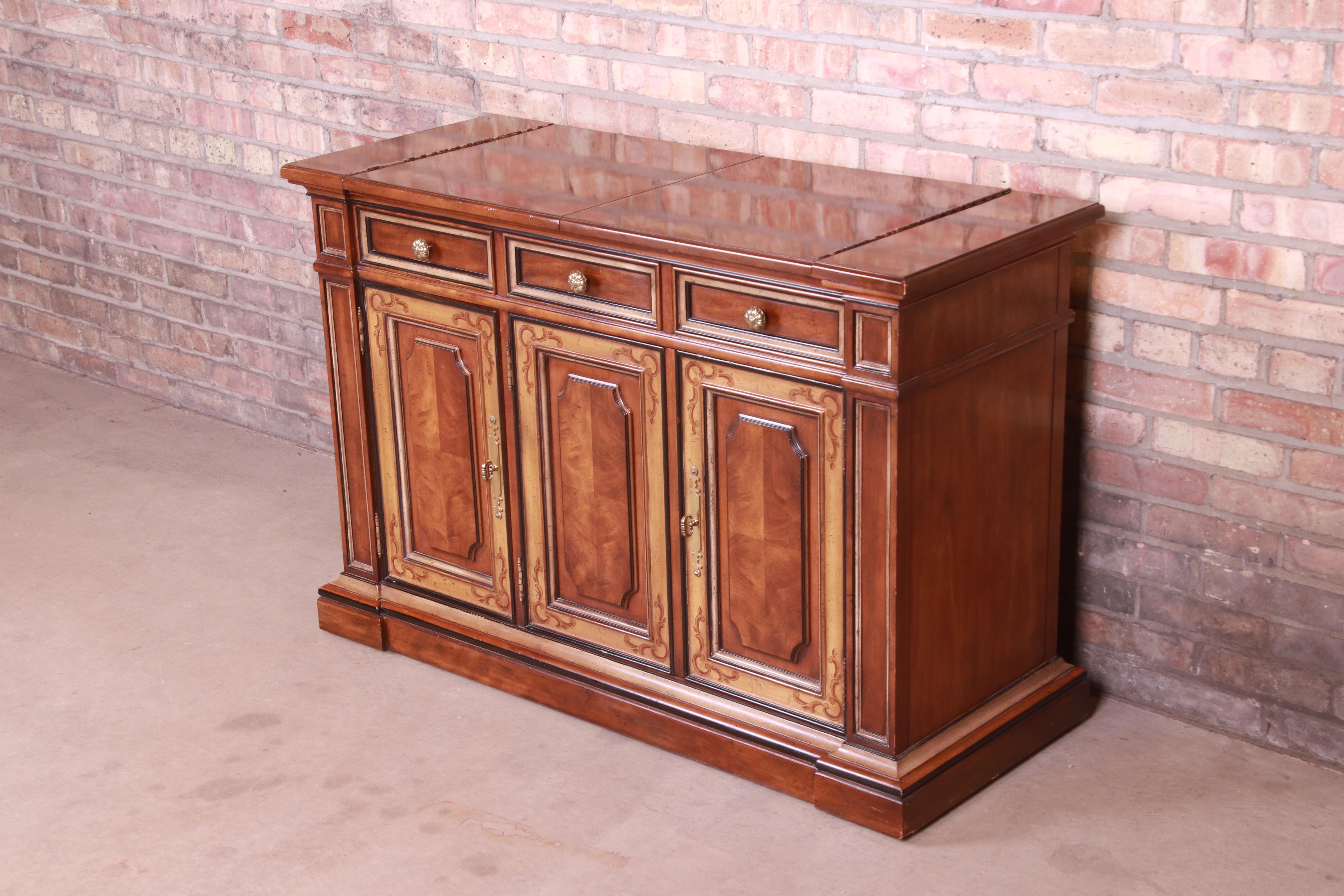 A gorgeous French Provincial flip-top sideboard, buffet server, or bar cabinet on casters

By Drexel Heritage

USA, Circa 1970s

Walnut, with hand-painted details and original brass hardware.

Measures: 47