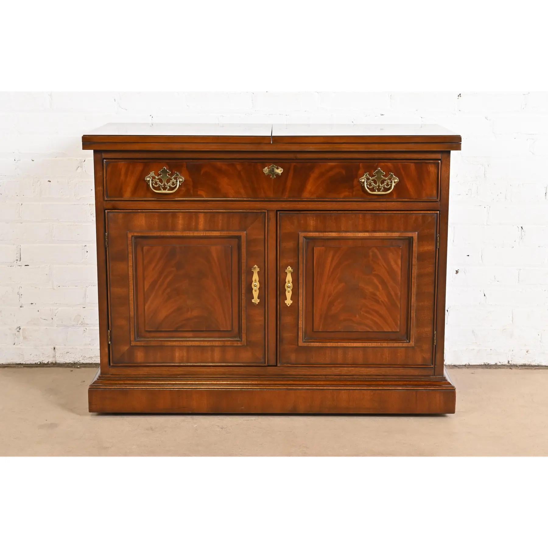 A beautiful Georgian or Chippendale style flip top rolling buffet server or bar cabinet

By Drexel Heritage

USA, Circa 1980s

Carved flame mahogany, with original brass hardware. Shelves are adjustable and bar is on casters.

Measures: 40.5