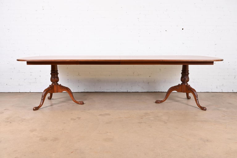 An exceptional Georgian or Chippendale style double pedestal extension dining table

By Drexel Heritage

USA, Circa 1980s

Stunning book-matched flame mahogany, with satinwood banding, and carved solid mahogany pedestals.

Measures: 74
