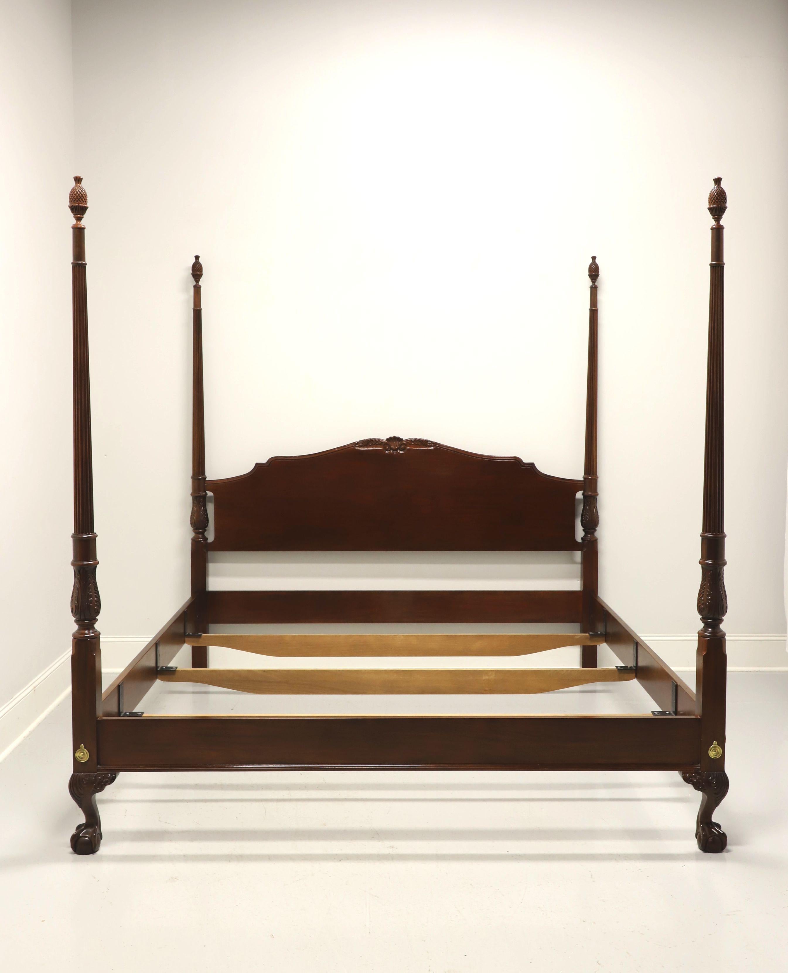 A Chippendale style king size poster bed by Drexel Heritage, from their Heirlooms Collection. Solid mahogany with decoratively carved arched headboard, four carved & fluted posts with finials, brass hardware, bolt held side rails with metal bracers,