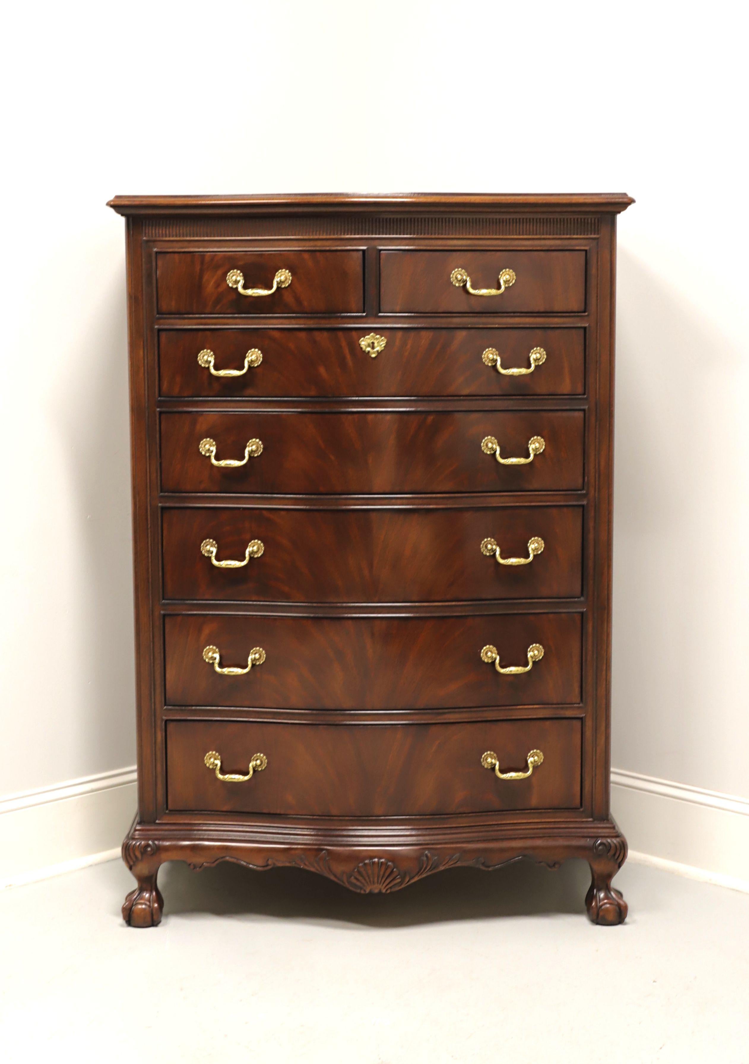 A Chippendale style chest of drawers by Drexel Heritage, from their Heirlooms Collection. Flame mahogany with serpentine front, brass hardware, fluting across top of front, decoratively carved apron with center shell, carved knees and ball in claw